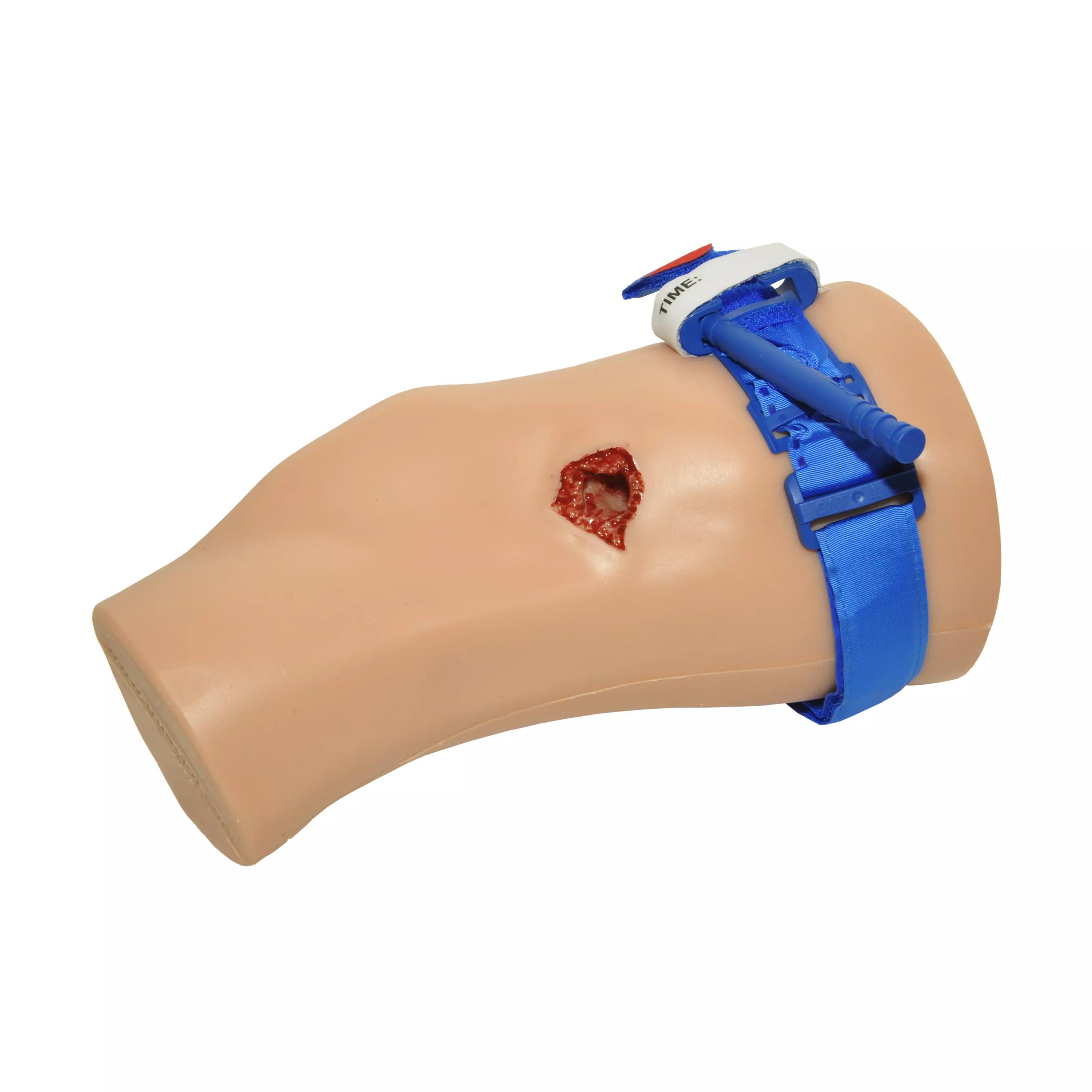 TrueClot® PCT3 Trainer Trainingspuppe aus beigem Kunststoff mit simuliertem Schnitt am Oberschenkel und einer blauen Time-Label-Gurtsicherung.