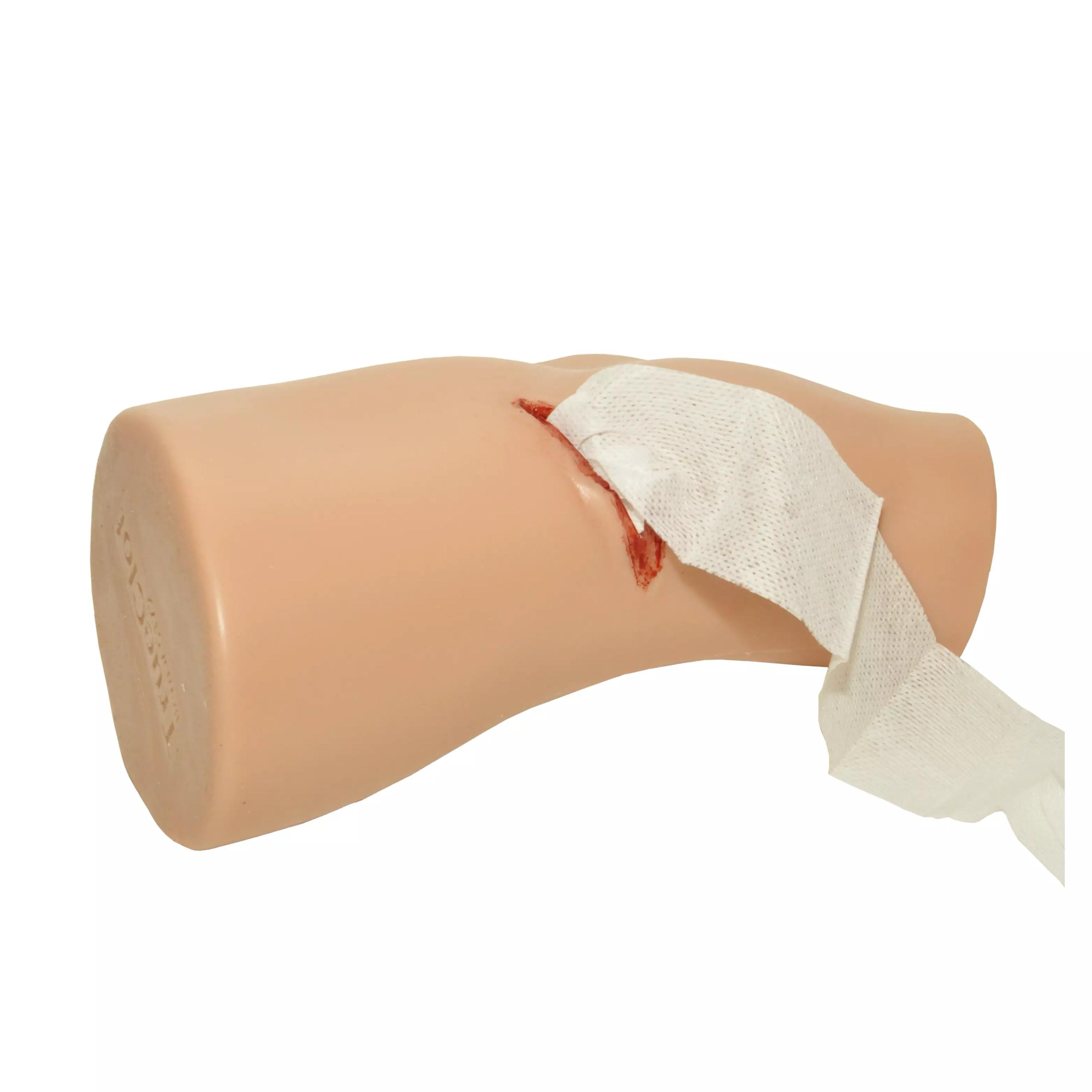 Der TrueClot® PCT3 Trainer zeigt ein beiges Bein mit simuliertem Schnitt und weißem Verband zur realistischen Wundversorgung im medizinischen Training.