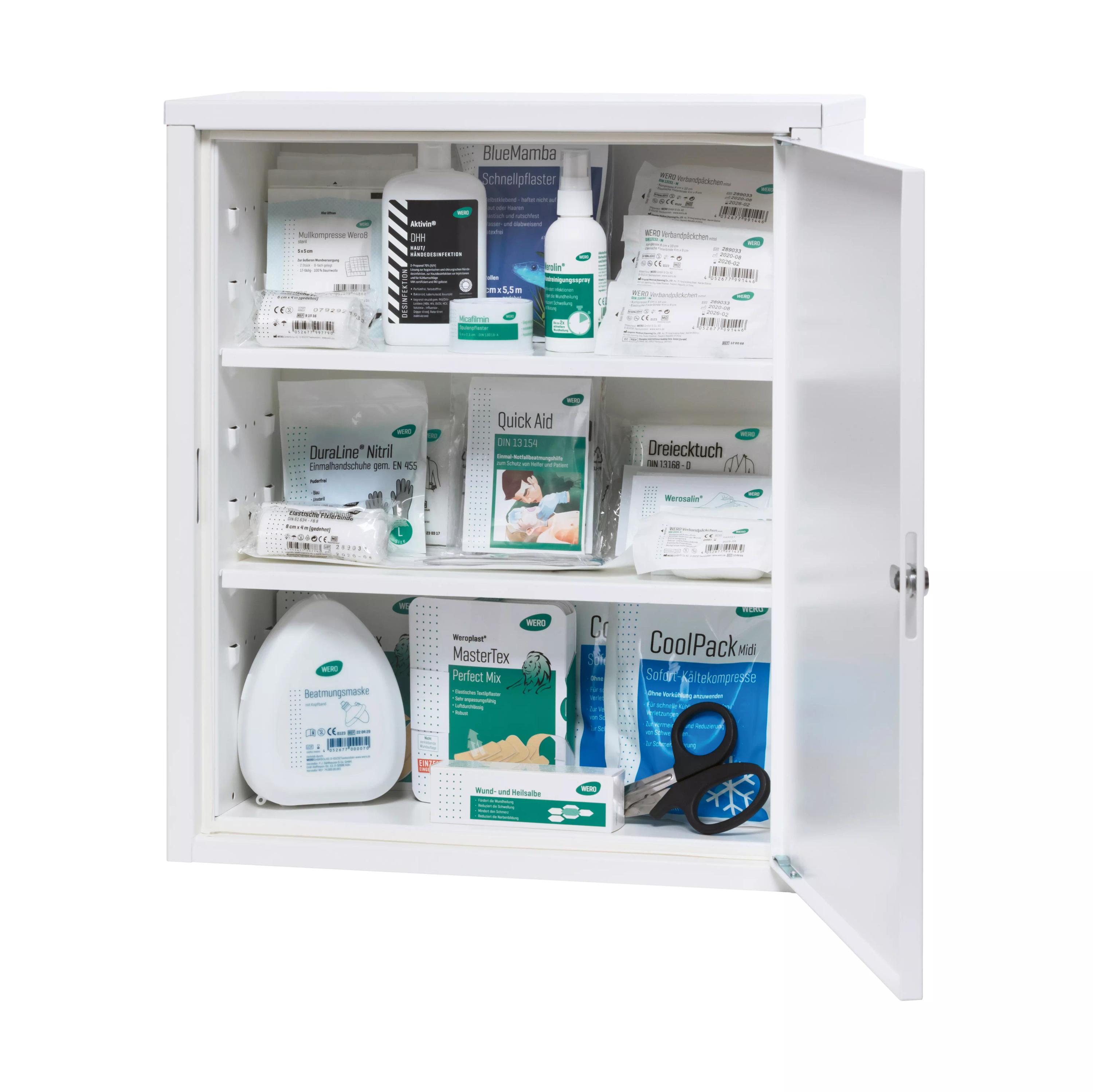 Geöffneter Medizinschrank mit Pflasterpackungen, Klebebandrollen, Alkoholtupferflasche und schwarzen Scheren auf zwei Regalböden