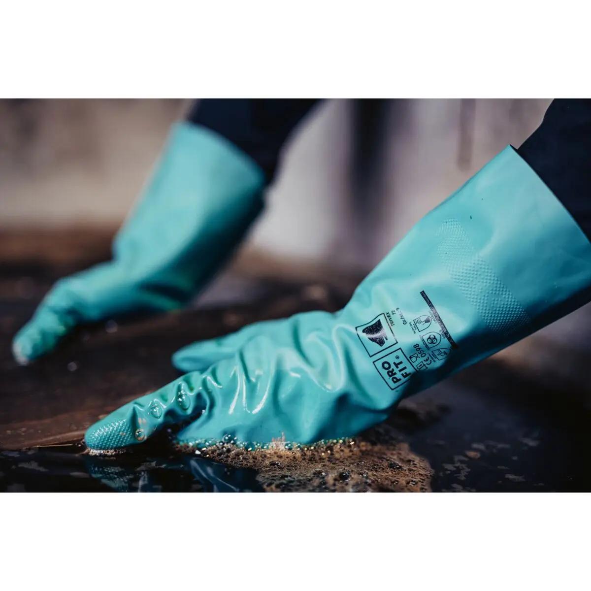 Zwei Hände mit Chemikalienschutzhandschuh Nitril 33, grün, wabenprofiliert und chemikalienbeständig, reinigen eine Oberfläche mit Seifenwasser.