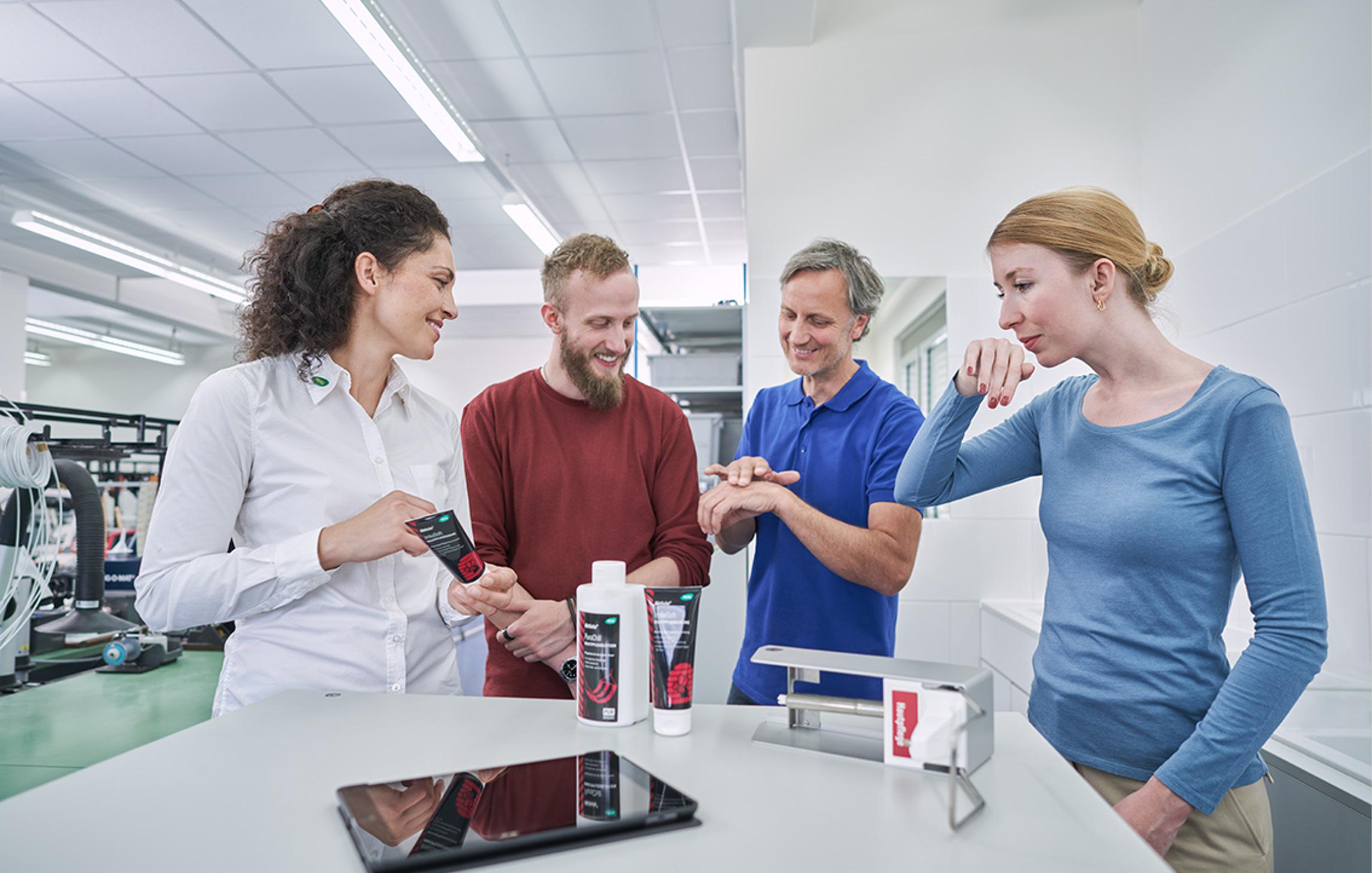 Eine WERO Mitarbeitende erklärt drei Personen verschiedene WERO Artikel für den Bereich Hautschutz und Hygiene