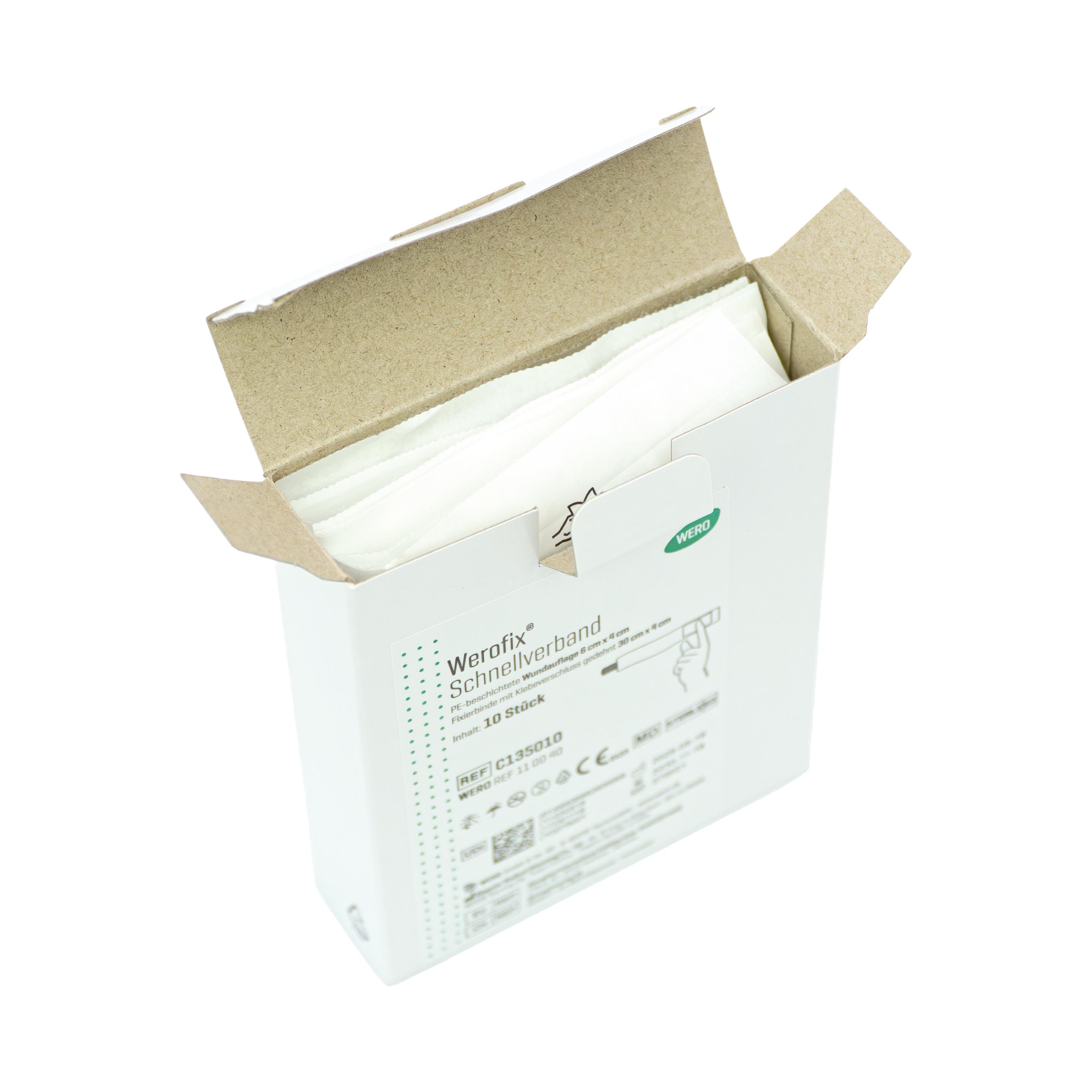 Geöffnete Werofix® Schnellverband, steril - 10 Stk Box mit sichtbarem weißen Verbandtuch, braunem Pappdeckel, Produktaufdruck und grünem Logo.