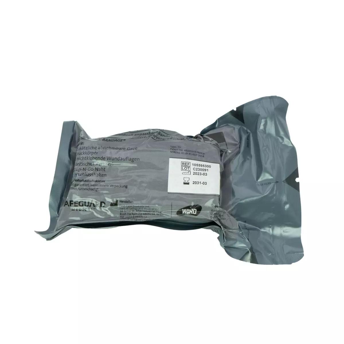 Ein einzeln verpackter, silbergrauer T3 Bandage™ Notfalldruckverband mit zwei Wundauflagen und zusätzlicher Mullbinde liegt zentral im Bild.
