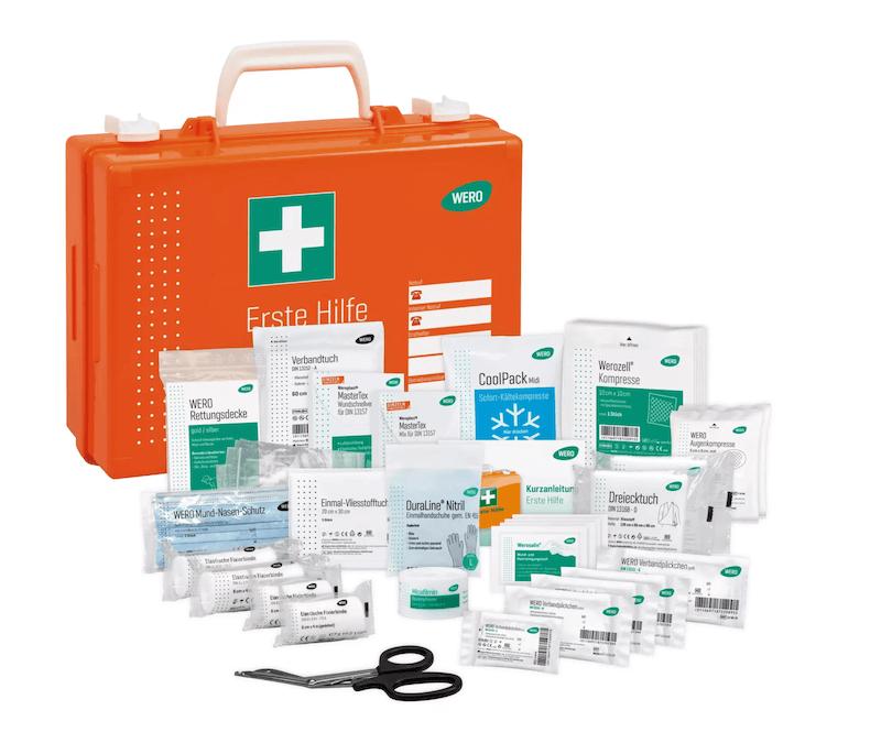 Orangefarbener Erste-Hilfe-Kasten mit grünem Kreuz, gefüllt mit Verbandmaterial, Desinfektionstüchern, Schere und „Erdurine Nitrile“-Spenderflasche