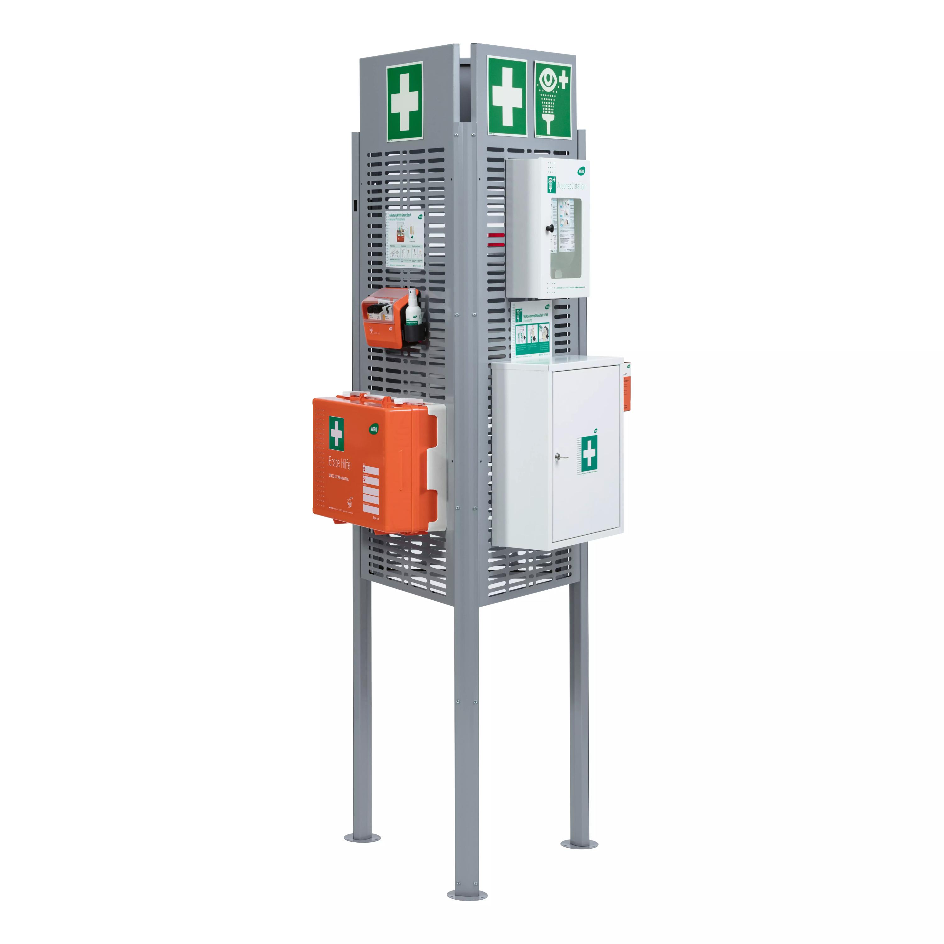 Ein grau-metallener Weroflex® Station - 3-Seiten Komplett-Set Notfallständer mit mehreren weißen Erste-Hilfe-Schränken, grünen Kreuzsymbolen und orangener Box.