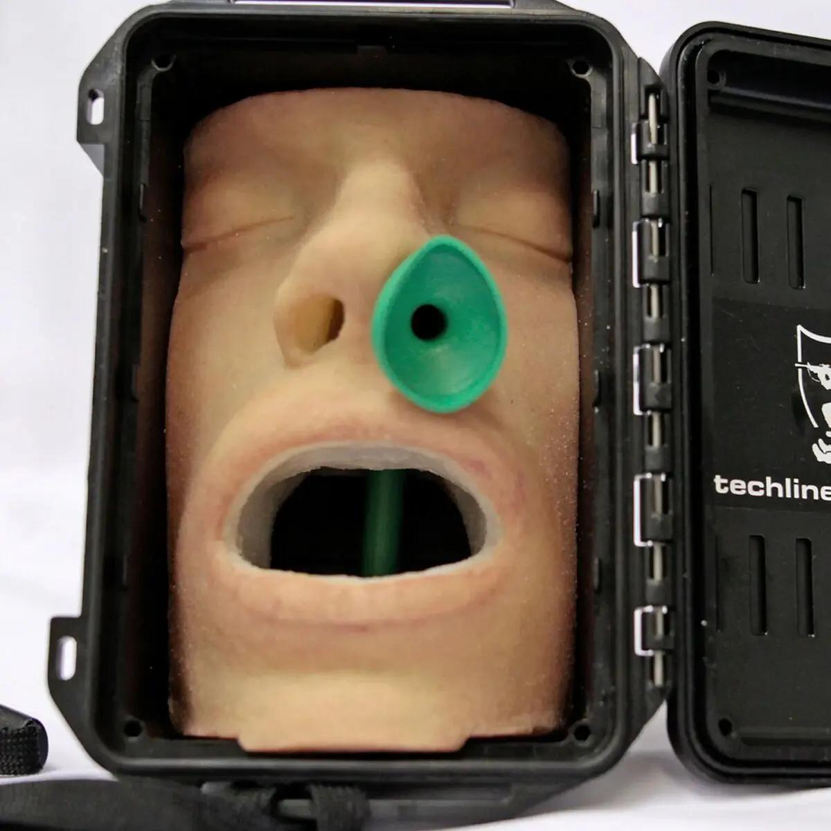 Der Techline Nasopharyngeal-/Wendl-Tubus-Trainer zeigt einen Dummy-Kopf mit eingeführtem Nasen- und Mundtubus sowie grünem Nasal-Katheter im schwarzen Koffer.