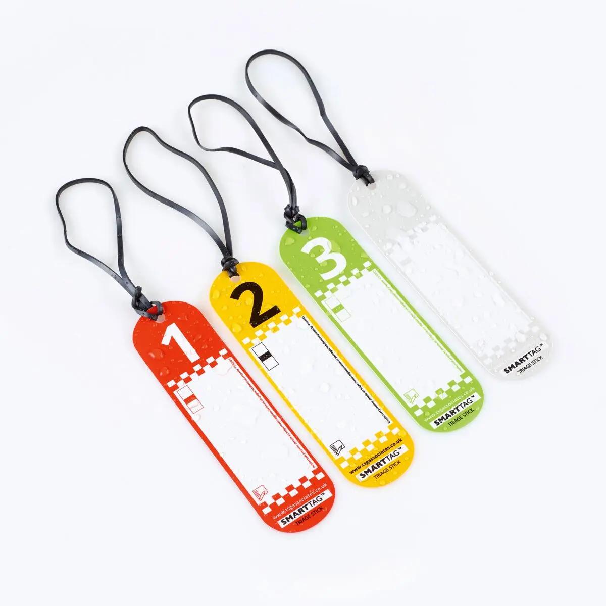 Vier verschiedenfarbige SmartTriage™ First Response - Set Anhänger mit Zahlen 1 bis 4 und schwarzer Kordel, jeweils mit auffälligem Muster unten.