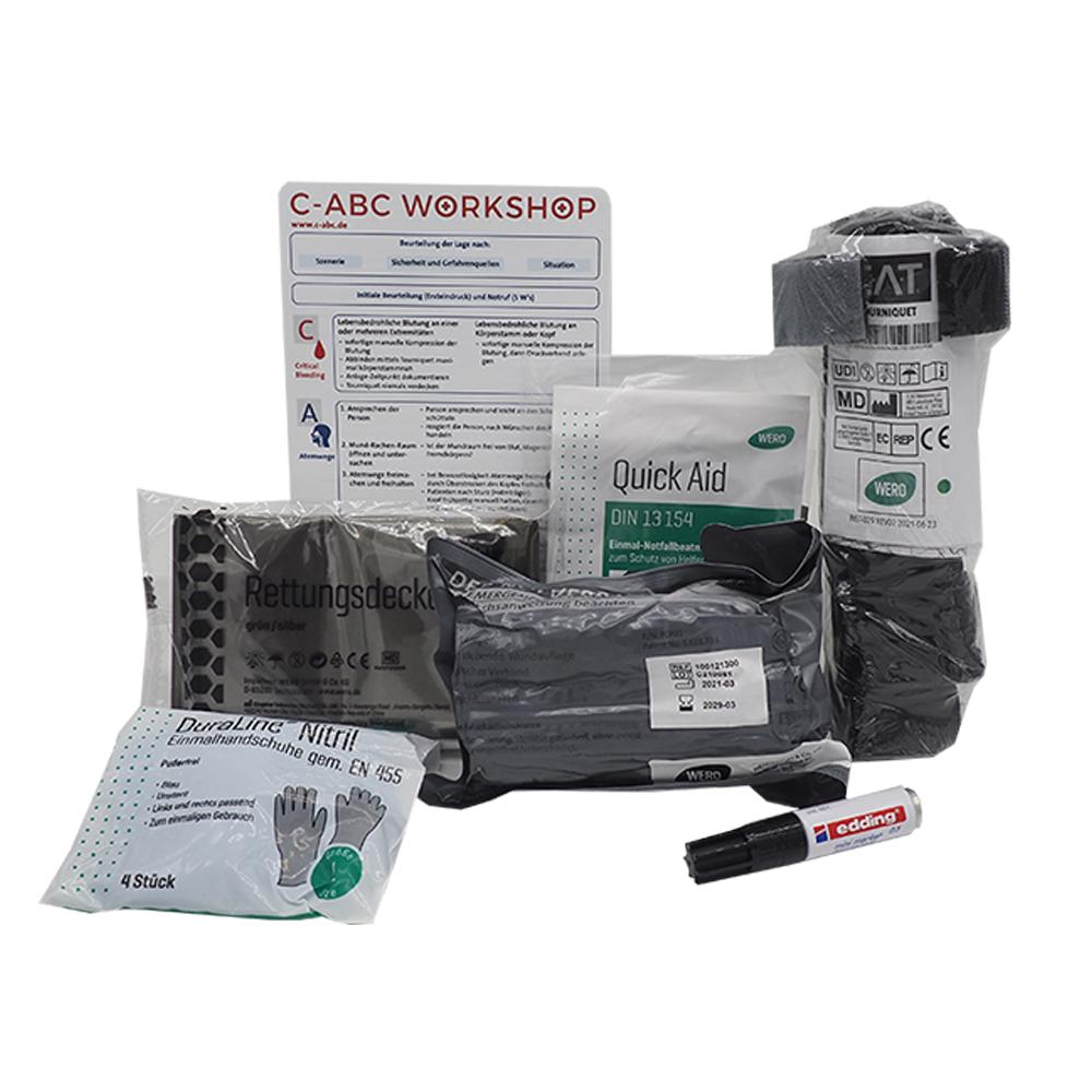 C-ABC Adventure Füllung mit schwarzen Handschuhen, Druckverband, Druckbeutel, Notfallbeatmungshilfe sowie Edding-Marker für Erstversorgung.