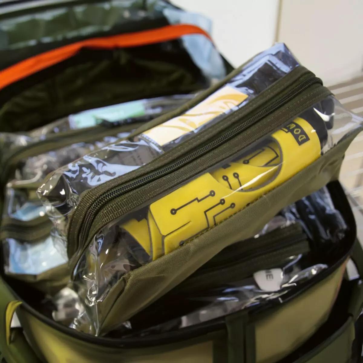 Ein geöffneter Notfallbeutel zeigt den gelben Immobilisationskragen Necklite™ samt sterilen, klaren Beuteln mit Zubehör wie gelbem Rohr.
