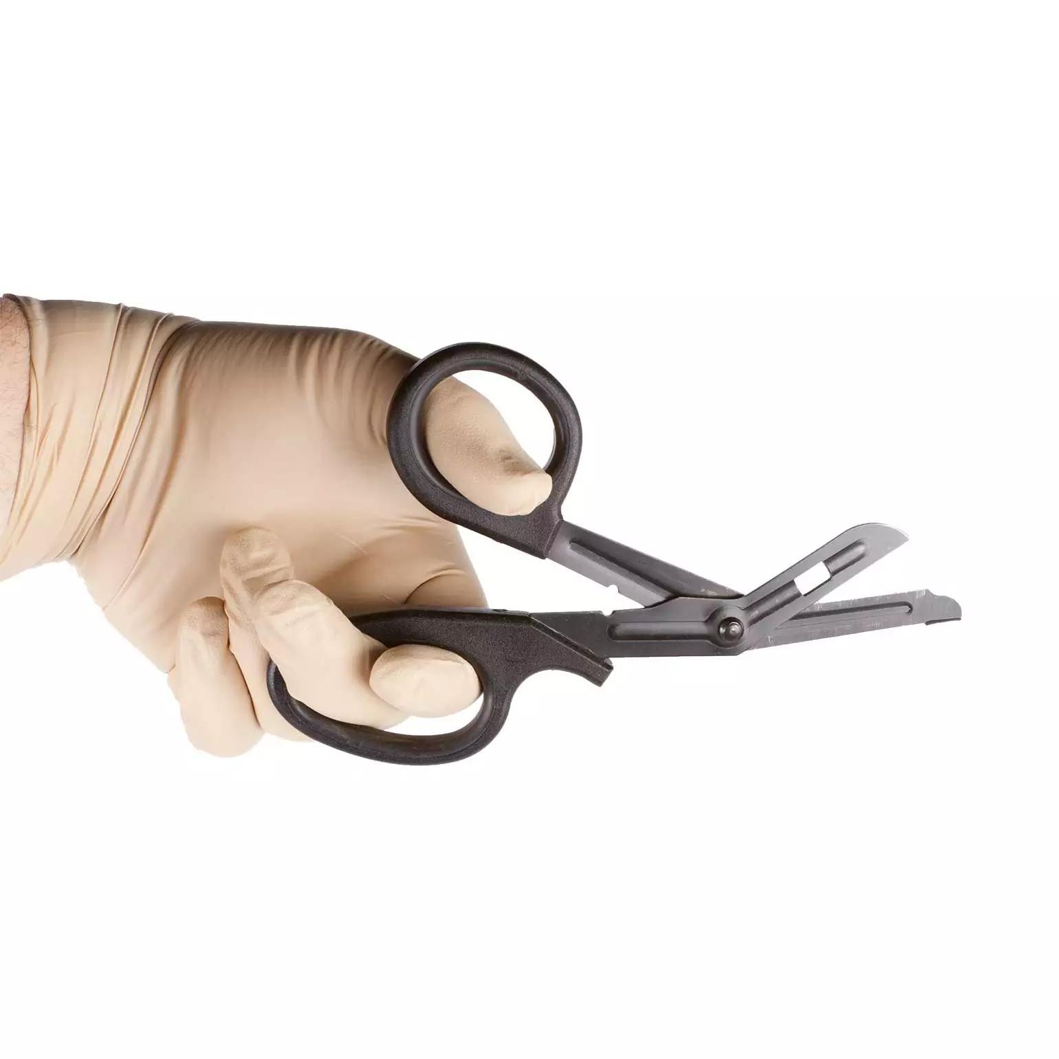 Eine Hand in sterilem Handschuh hält geöffnete NAR Trauma Shear - 18,5 cm mit schwarzen Griffen und Edelstahlklinge zum präzisen Schneiden.