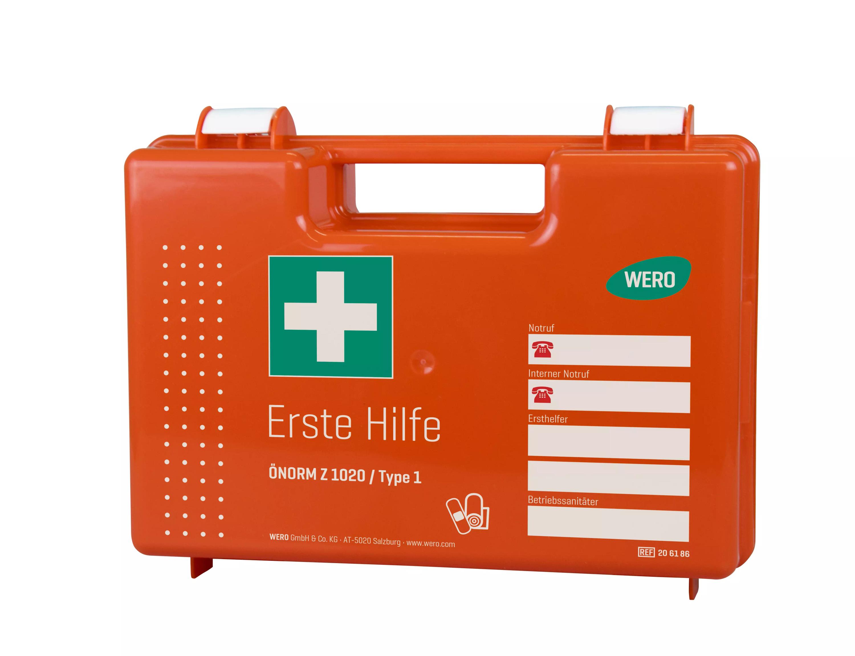 Orangefarbener Erste Hilfe Koffer mit WERO Basis Füllung ÖNORM Z 1020 Typ 1, weißem Griff, grünem Kreuz und Formularfeld auf der Vorderseite.