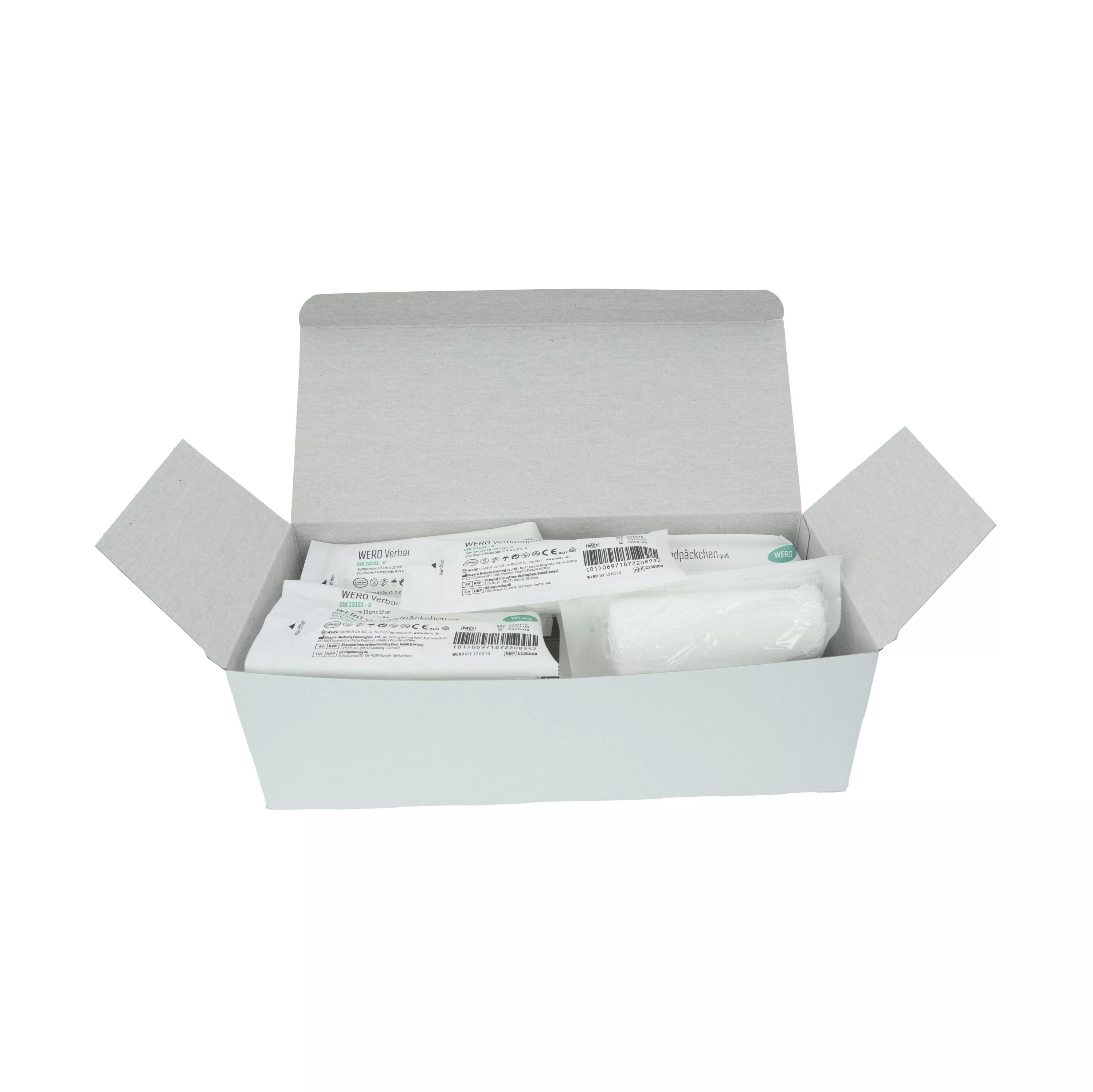 Eine offene Schachtel mit 15 einzeln steril verpackten WERO Verbandpäckchen DIN 13151 G, deren Kompressen mit Spezialbeschichtung versehen und aluminiumfrei sind.