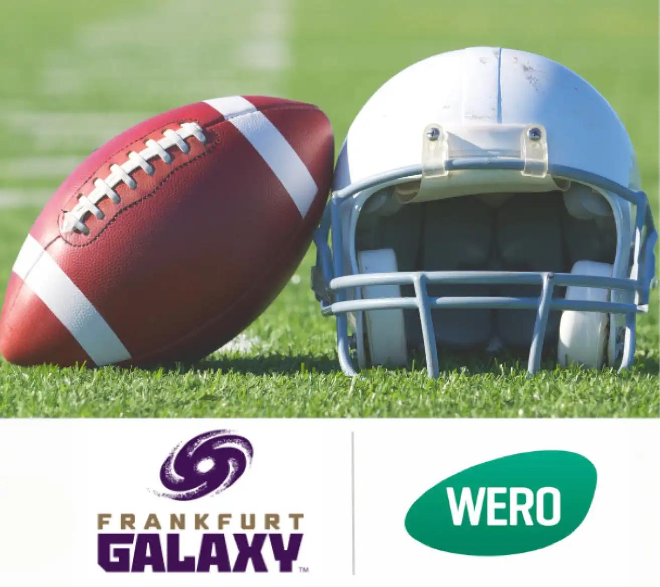 Roter Football mit weißen Schnürsenkeln und weißem Streifen neben einem weiß-blauen Helm, Logos von Frankfurt Galaxy und WERO im Hintergrund.