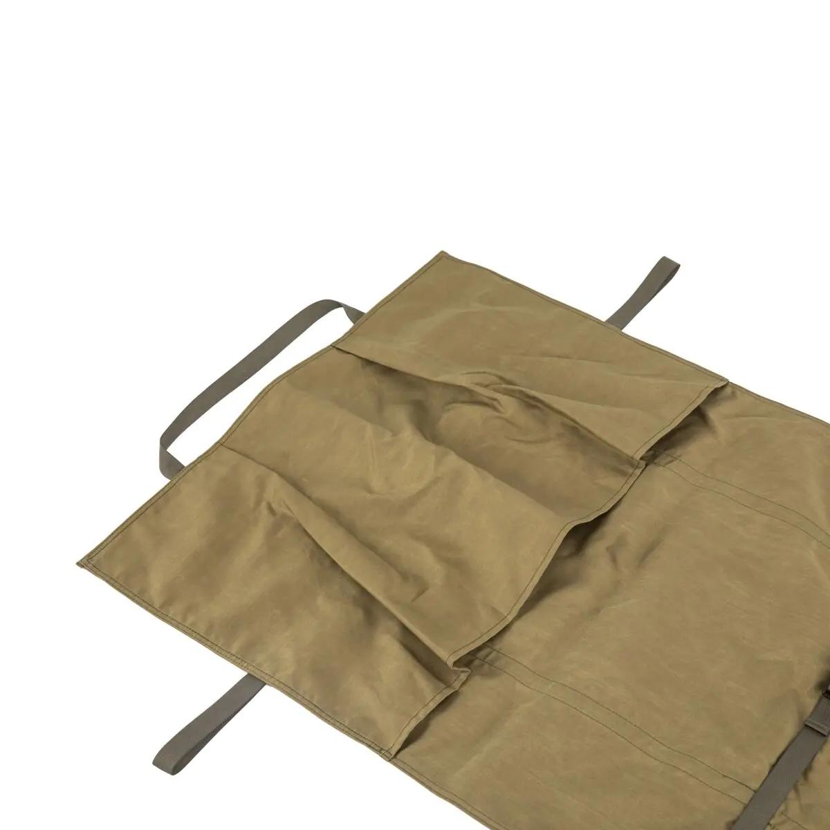 Zusammengefaltetes Retmex® Combat - Rettungstuch mit angenähtem Fußsack, robustem Griff und mehreren aufgenähten Taschen zur Aufbewahrung.
