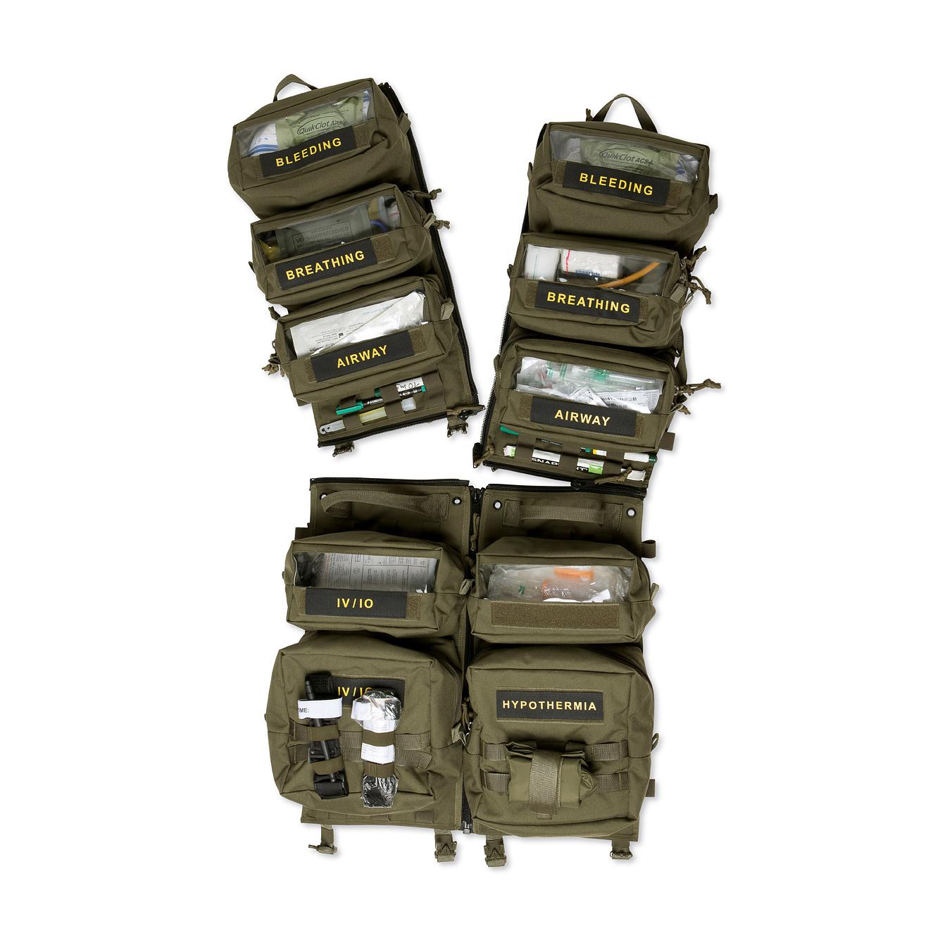 Acht dunkelgrüne TT Medic Transporter Taschen sind geöffnet, gefüllt mit medizinischem Equipment und jeweils mit „bleeding“, „breathing“, „airway“ oder „hypothermia“ beschriftet.
