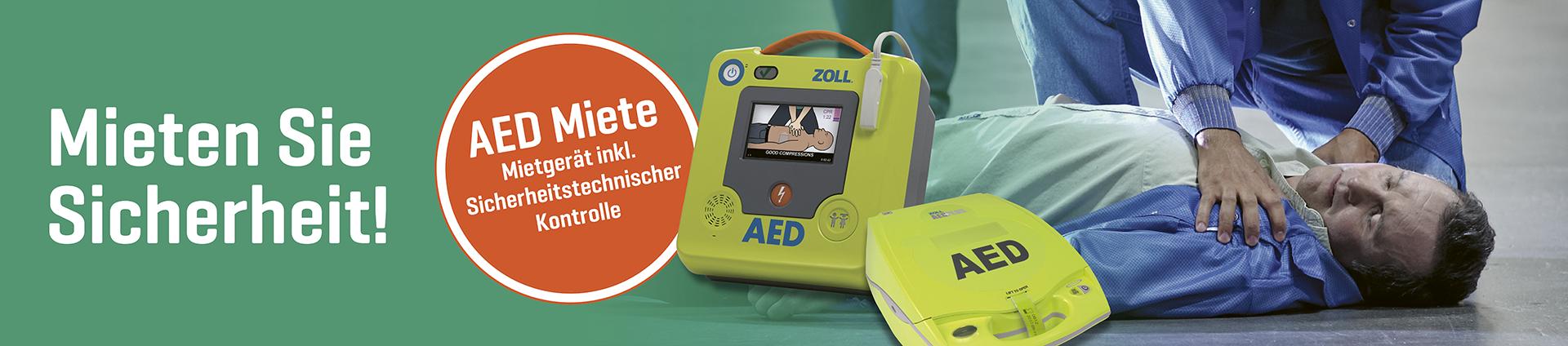 Eine Person wendet ein grünes AED Defibrillator Gerät an einem liegenden Patienten an.