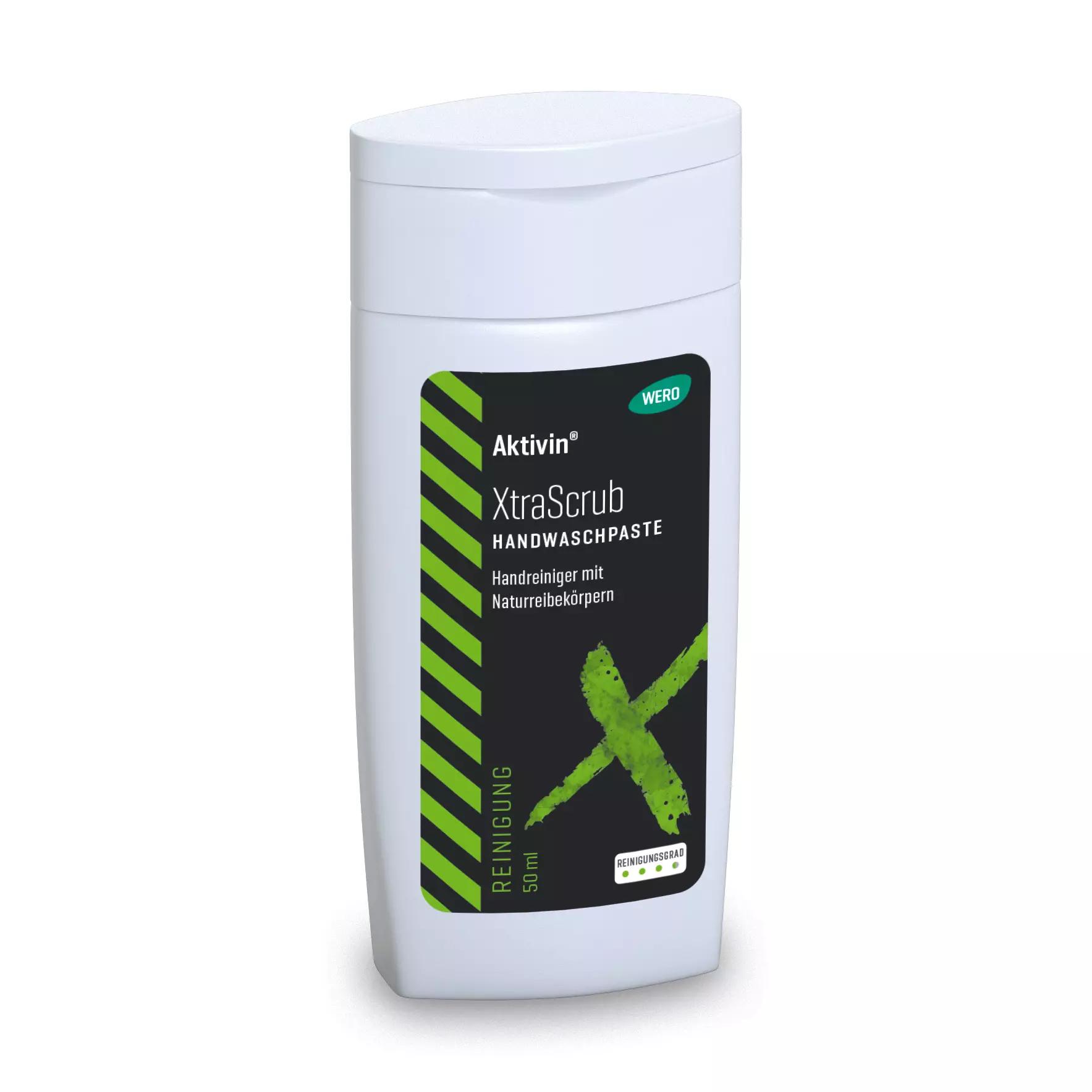 Weiße Flasche Hautreinigung Aktivin® XtraScrub - Probiergröße, 50 ml mit grünem Deckel, schwarzem Etikett und grünem X, enthält Walnussschalen-Reibekörper.