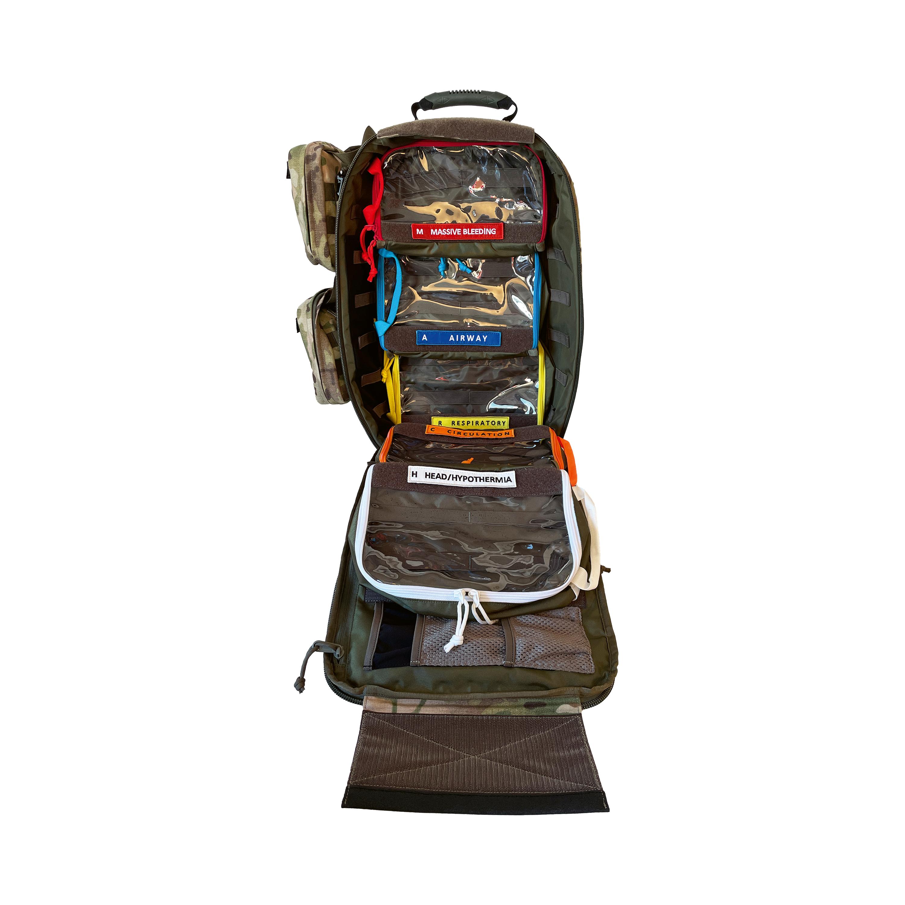 Offener Camouflage-Rucksack mit Fächern, klarem Organizer-Inhalt und beschrifteten Zipper-Beuteln für Erste-Hilfe-Artikel wie „AIRWAY“ und „HEAD/HYPO/THERMALIA“