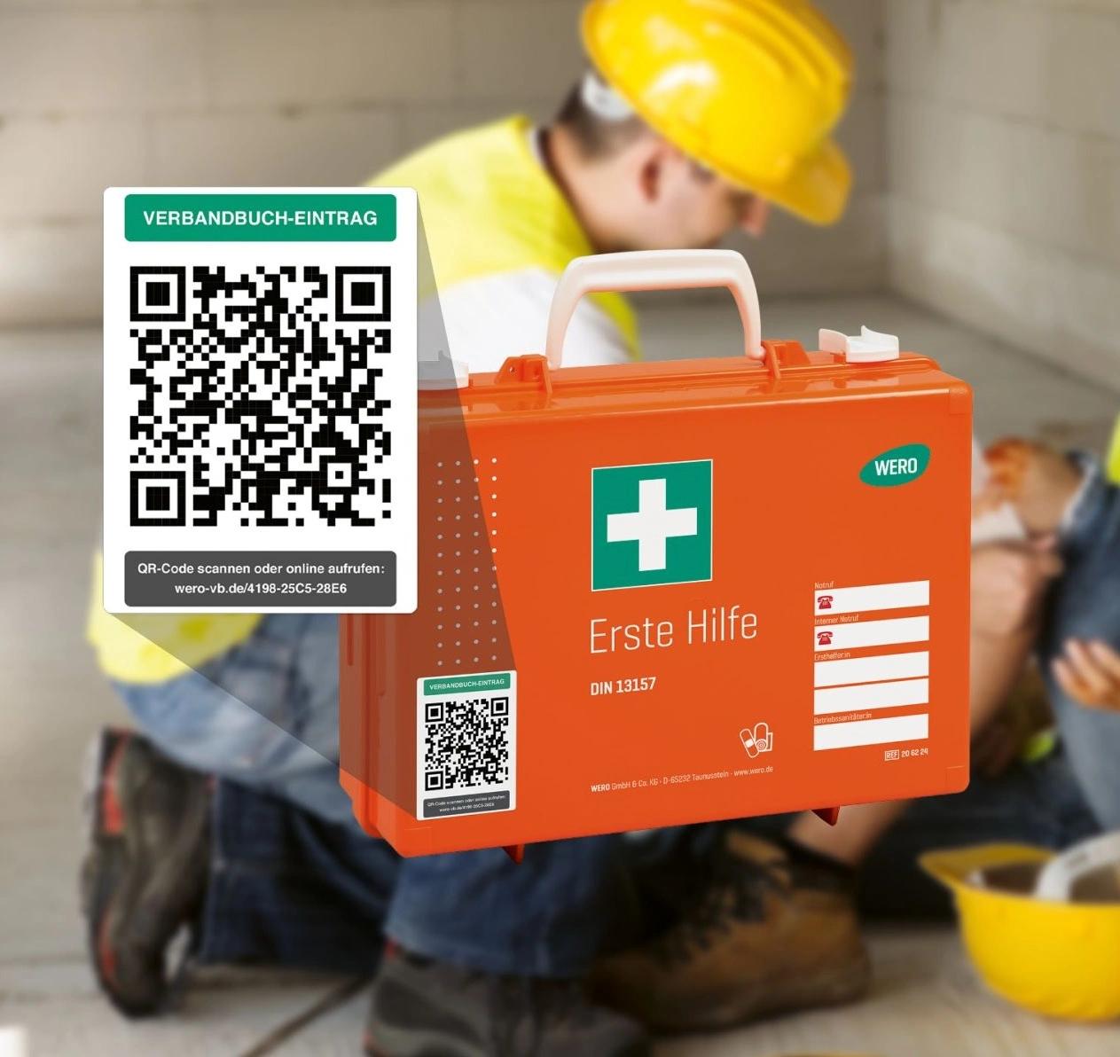 Orangefarbener Erste-Hilfe-Kasten mit grünem Kreuz, QR-Code und Notfallkontakt, davor gelber Schutzhelm auf dem Boden.