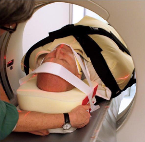 Eine Person liegt auf der Trauma Matratze CM TraumaMattress™, komplett bedeckt, während ein medizinischer Fachmann sie für eine bildgebende Untersuchung positioniert.