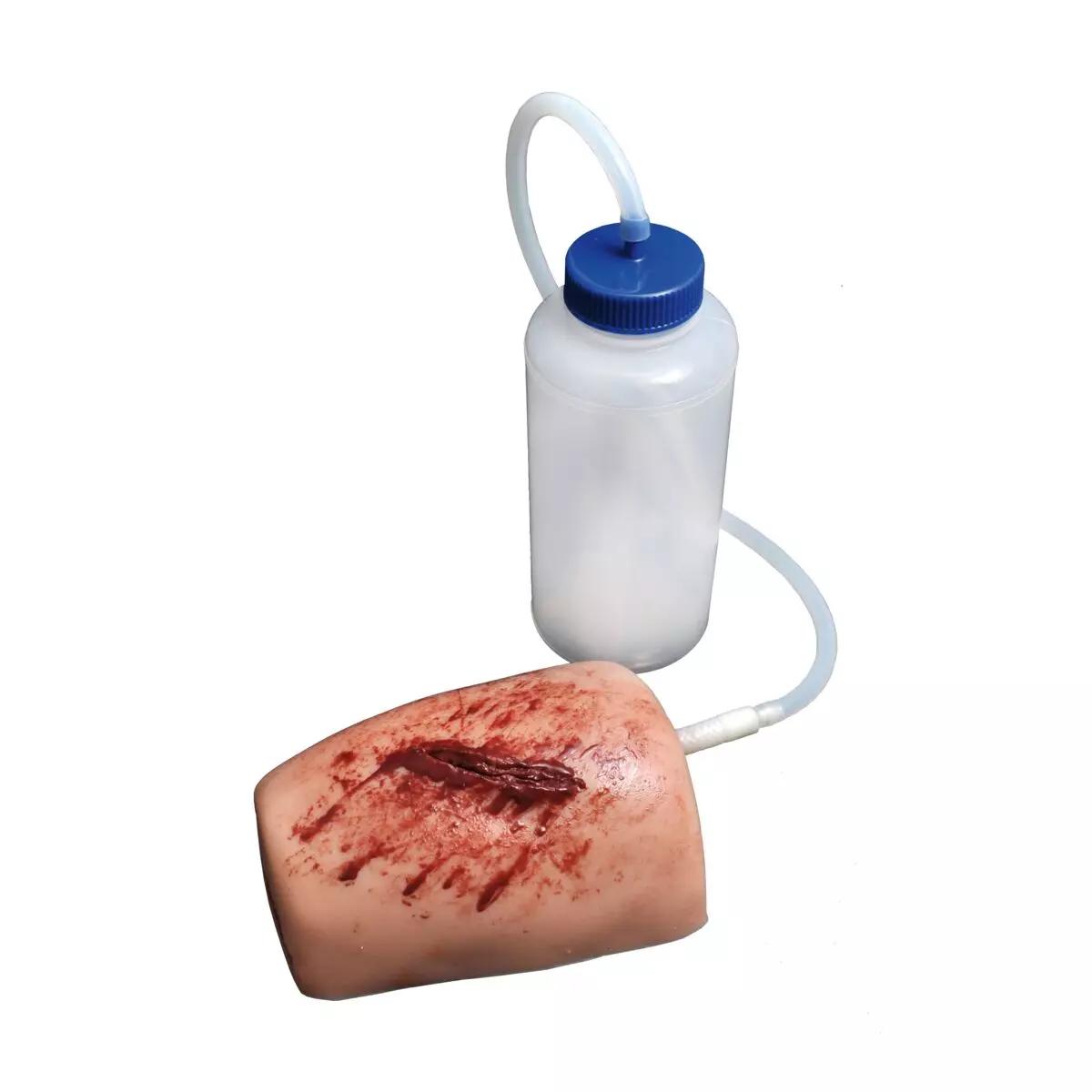 Ein realistischer Modellarm mit blutender Schnittwunde aus dem TrueClot® Wound Packing Trainingssystem, angeschlossen an eine Flasche für Blutstillungstraining.
