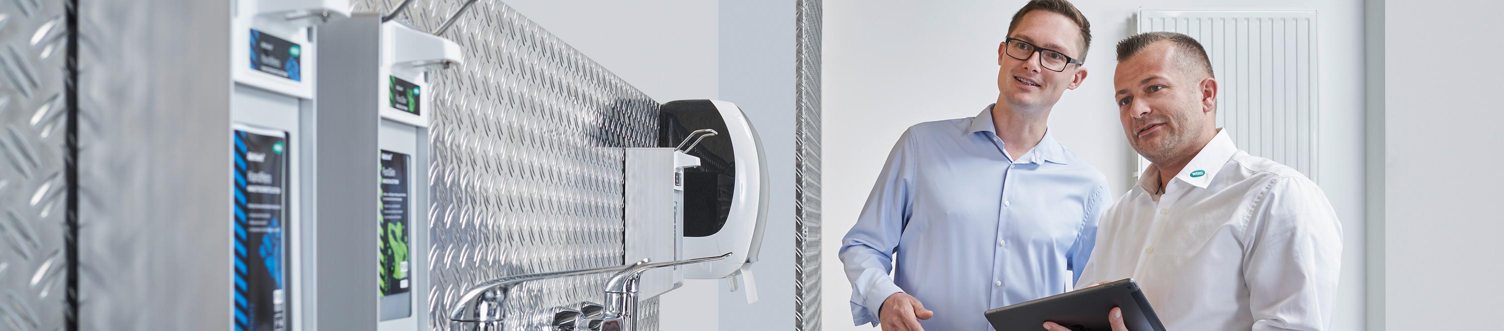 Zwei Personen kontrollieren die Platzierung von Spendersystemen.