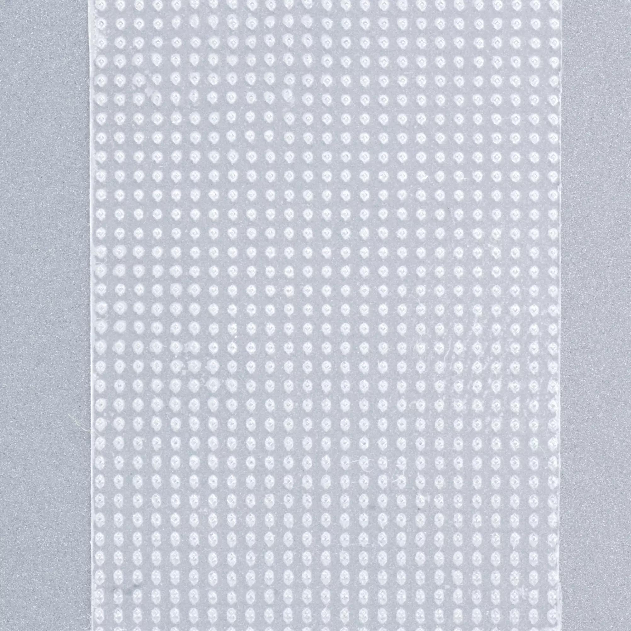 Ein rechteckiges Stück Micafilmin-Spulenpflaster, Flex-Pflaster, haftet waagerecht mit strukturierter Oberfläche auf einer glatten, hellgrauen Wand.