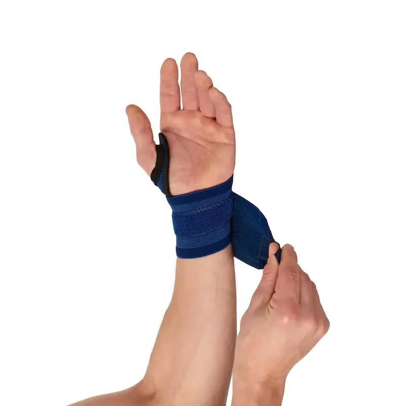 Blaues, flexibles Handgelenkband mit schwarzer Umrandung wird um ein linkes Handgelenk gelegt und durch einen Gurt sicher fixiert.