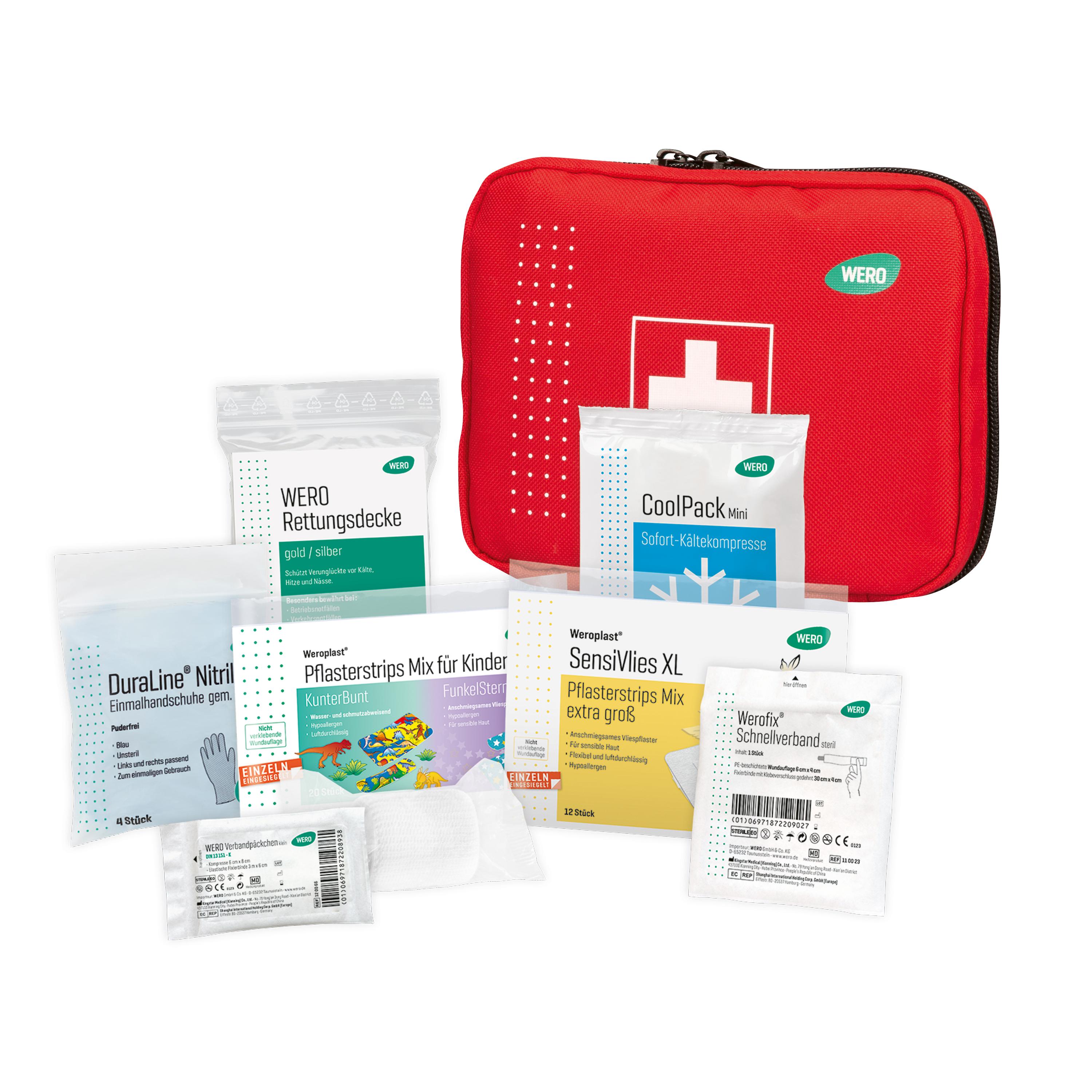 Ein offenes rotes First Aid Kit zeigt übersichtlich verschiedene medizinische Hilfsmittel wie Verbände, Desinfektionsmittel und Kühlpack.