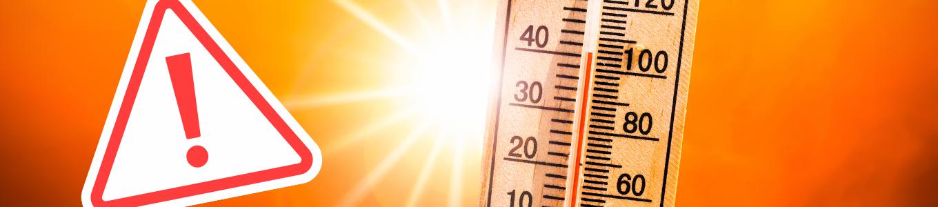 Holz-Thermometer mit Fahrenheit-Skala und Warnschild mit Ausrufezeichen vor orangefarbenem Hintergrund.