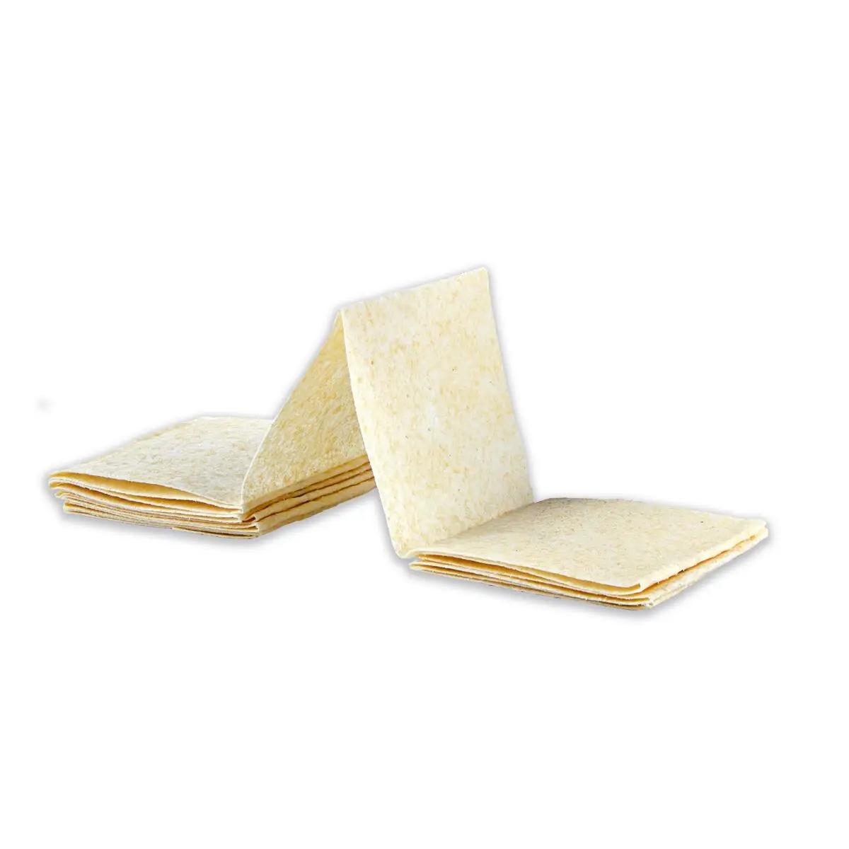 Mehrere leicht überlappende Celox™ Gauze - Hämostatische Gaze Stücke mit cremefarbener, fein texturierter Oberfläche sind gestapelt zu sehen.