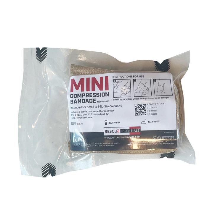 Eine ungeöffnete Rescue Essentials® Mini Compression Bandage im Klarsichtbeutel mit klar lesbarer Produktkennzeichnung und Angaben zur sterilen Kompresse.