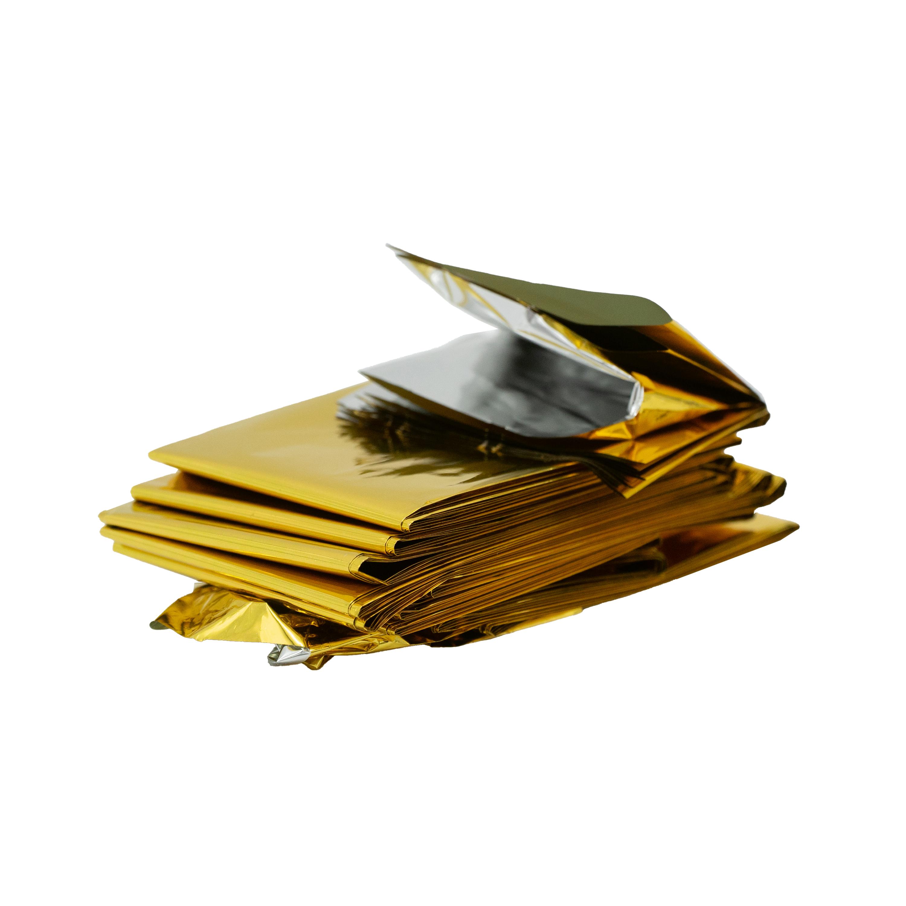Ein Stapel goldfarben verpackter WERO Rettungsdecke, glänzende Folie, oberstes Päckchen leicht geöffnet, zeigt reflektierende Innenfolie.