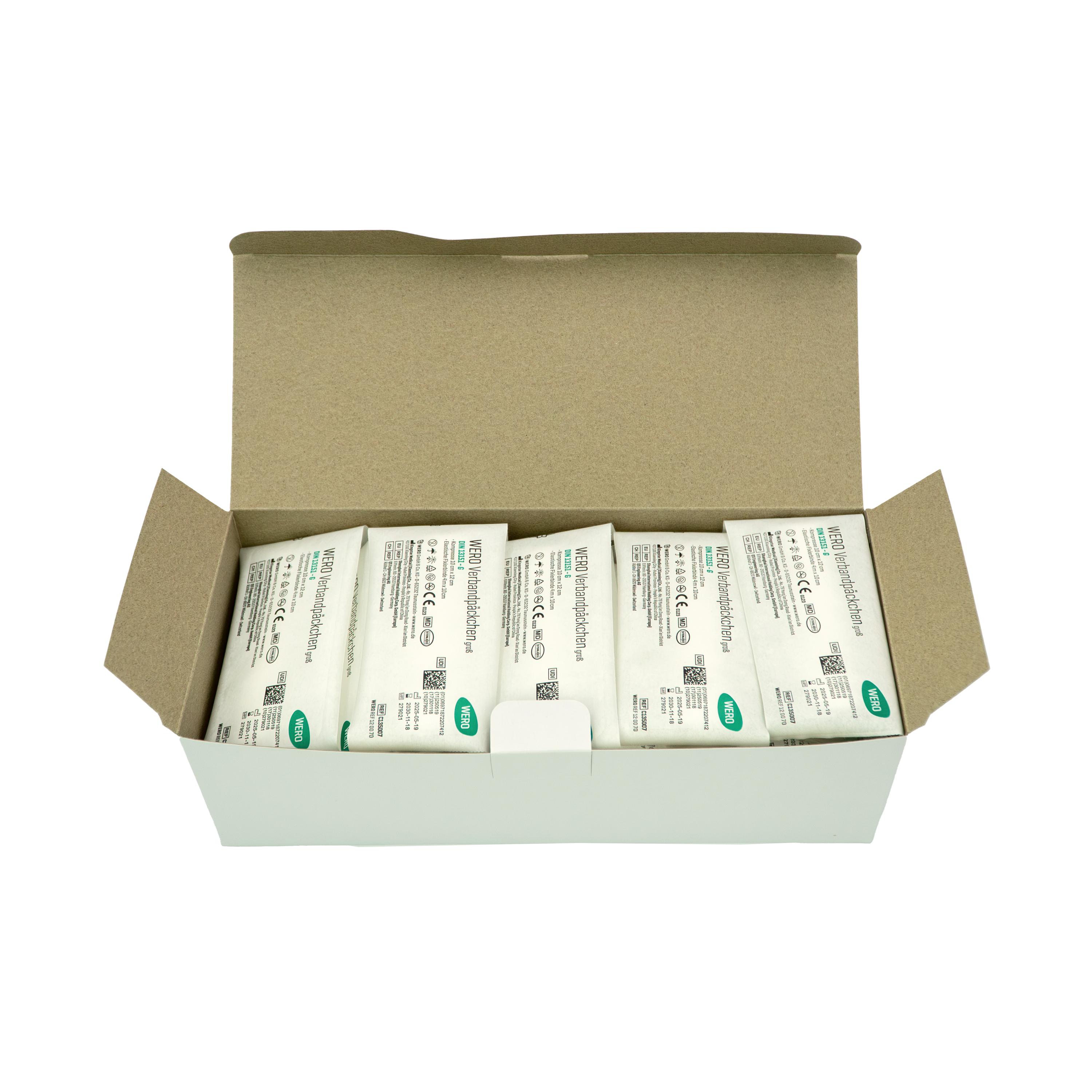 Sechs WERO Verbandpäckchen DIN 13151 G mit Spezialbeschichtung liegen steril verpackt in einer weißen Kartonbox in zwei Reihen.