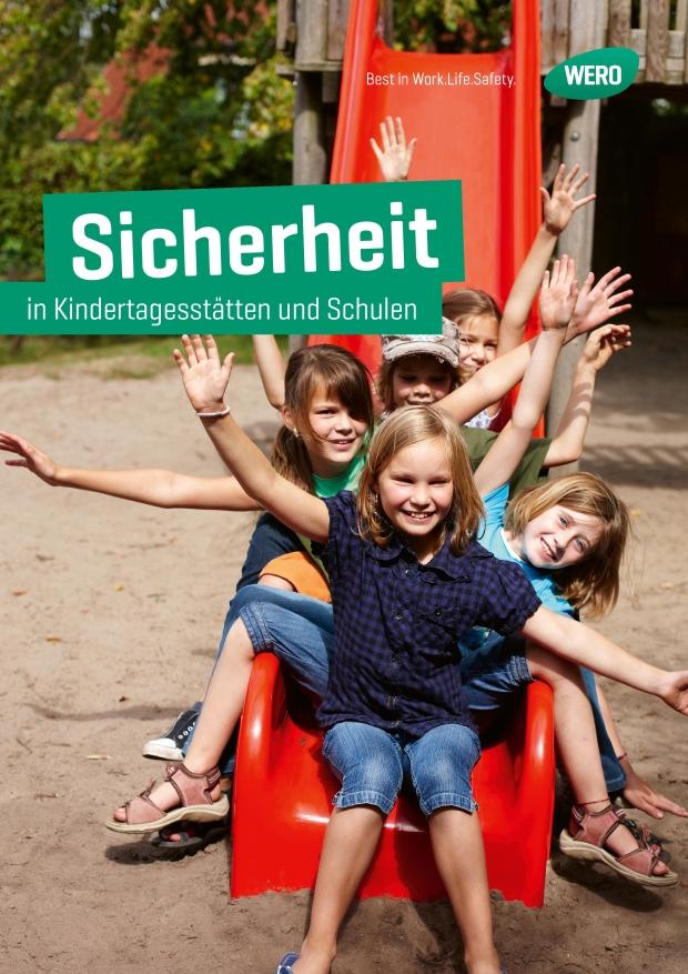 Drei lachende Kinder mit bunten Rucksäcken jubeln vor einer Tafel, Posteraufschrift: "Sicherheit in Kindertagessätten und Schulen".