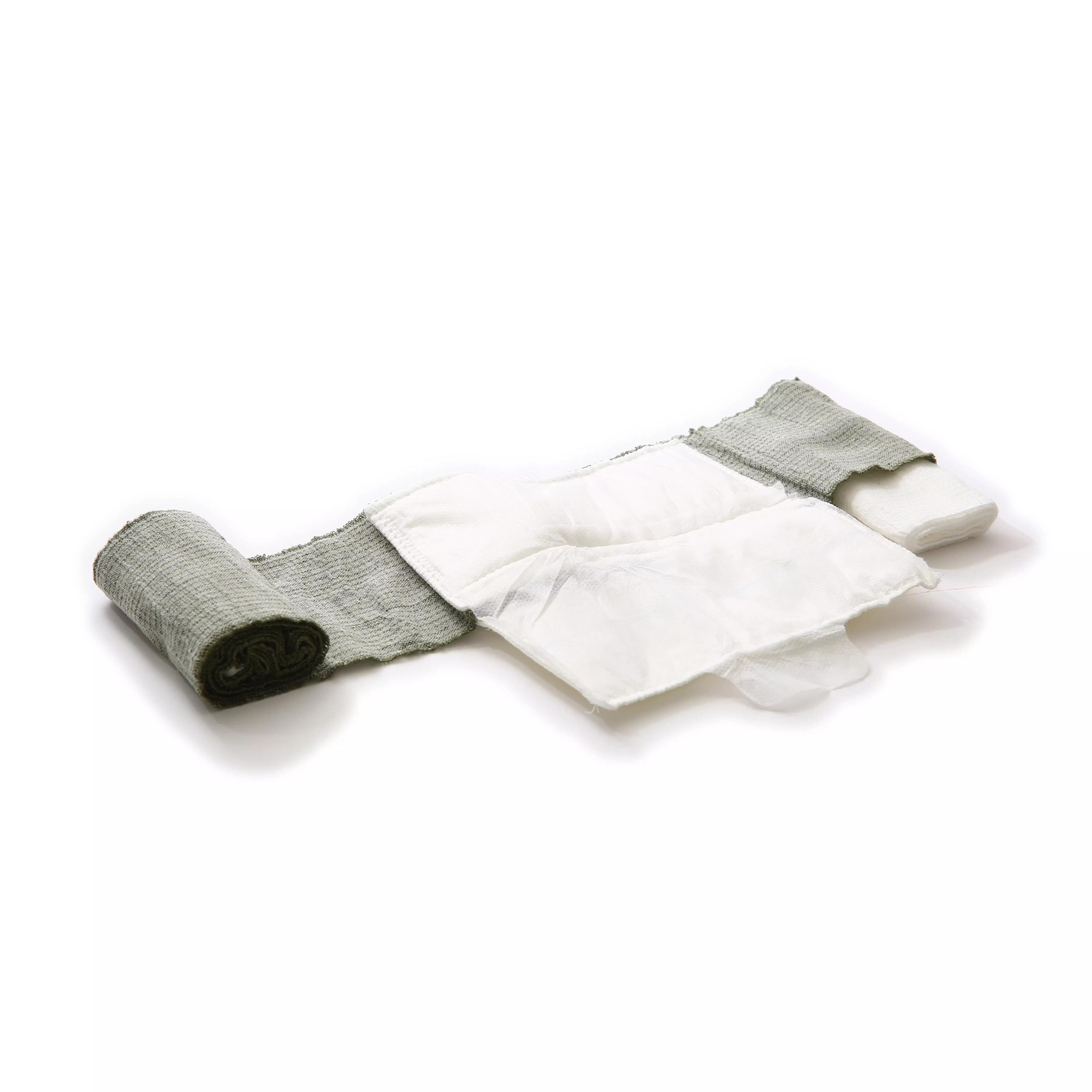 Eine aufgerollte grüne T3 Bandage™ liegt seitlich, mit teilweise entrollter, flexibler Struktur und befestigter rechteckiger Wundauflage.