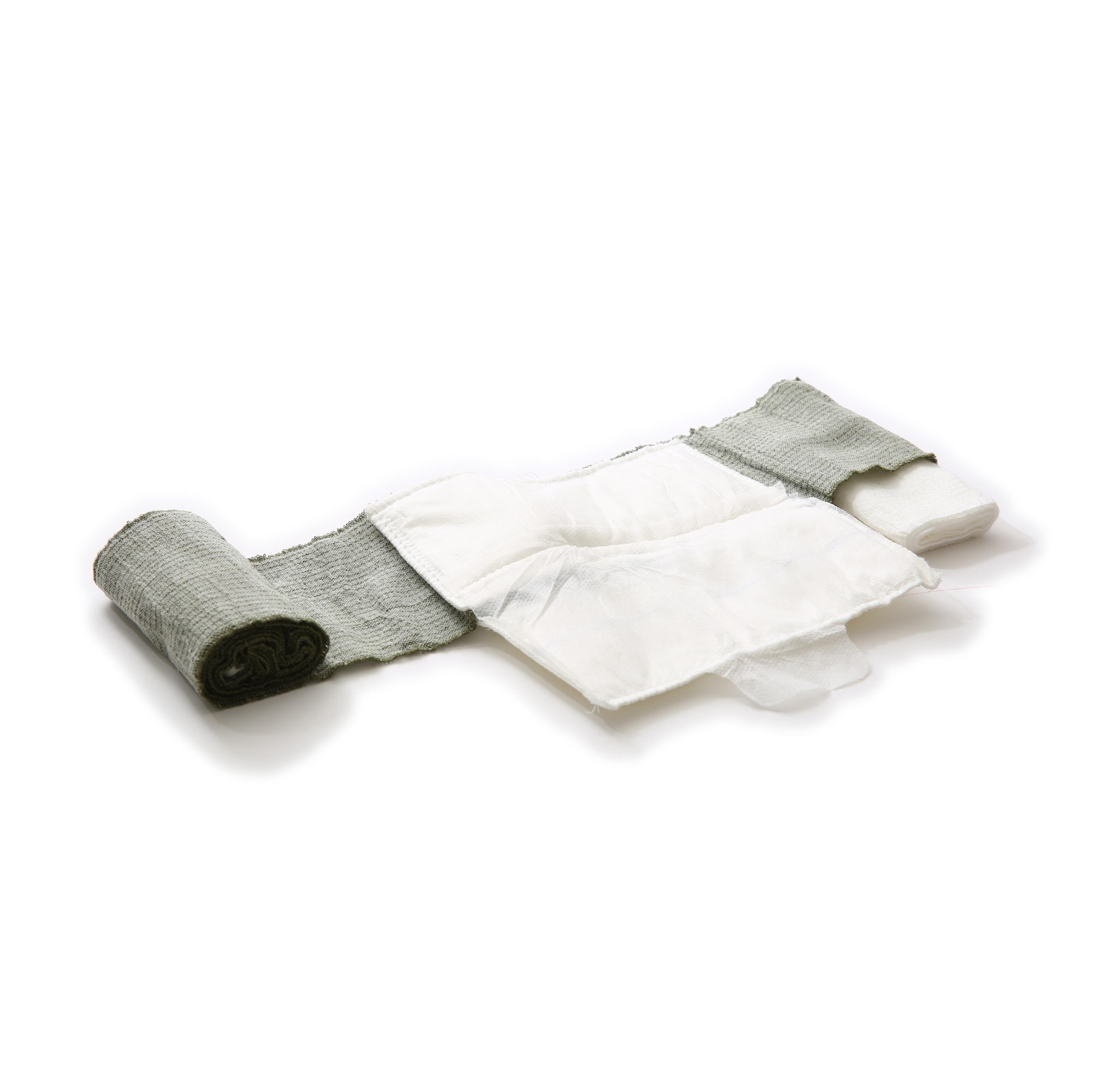Eine aufgerollte grüne T3 Bandage™ liegt seitlich, mit teilweise entrollter, flexibler Struktur und befestigter rechteckiger Wundauflage.