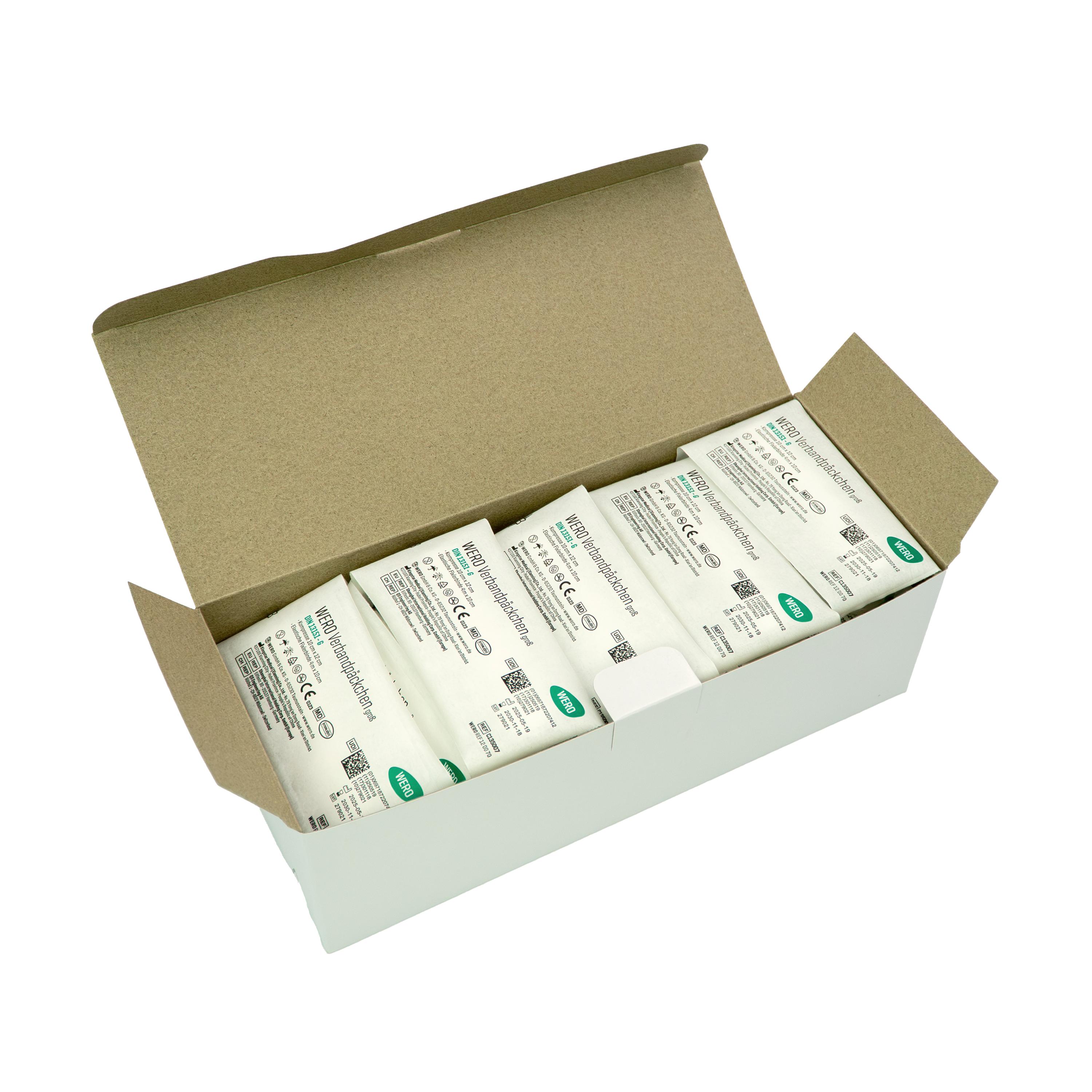 Ein offener Karton mit sechzehn WERO Verbandpäckchen DIN 13151 G, steril, zeigt einzeln verpackte, aluminiumfreie Kompressen mit Spezialbeschichtung.