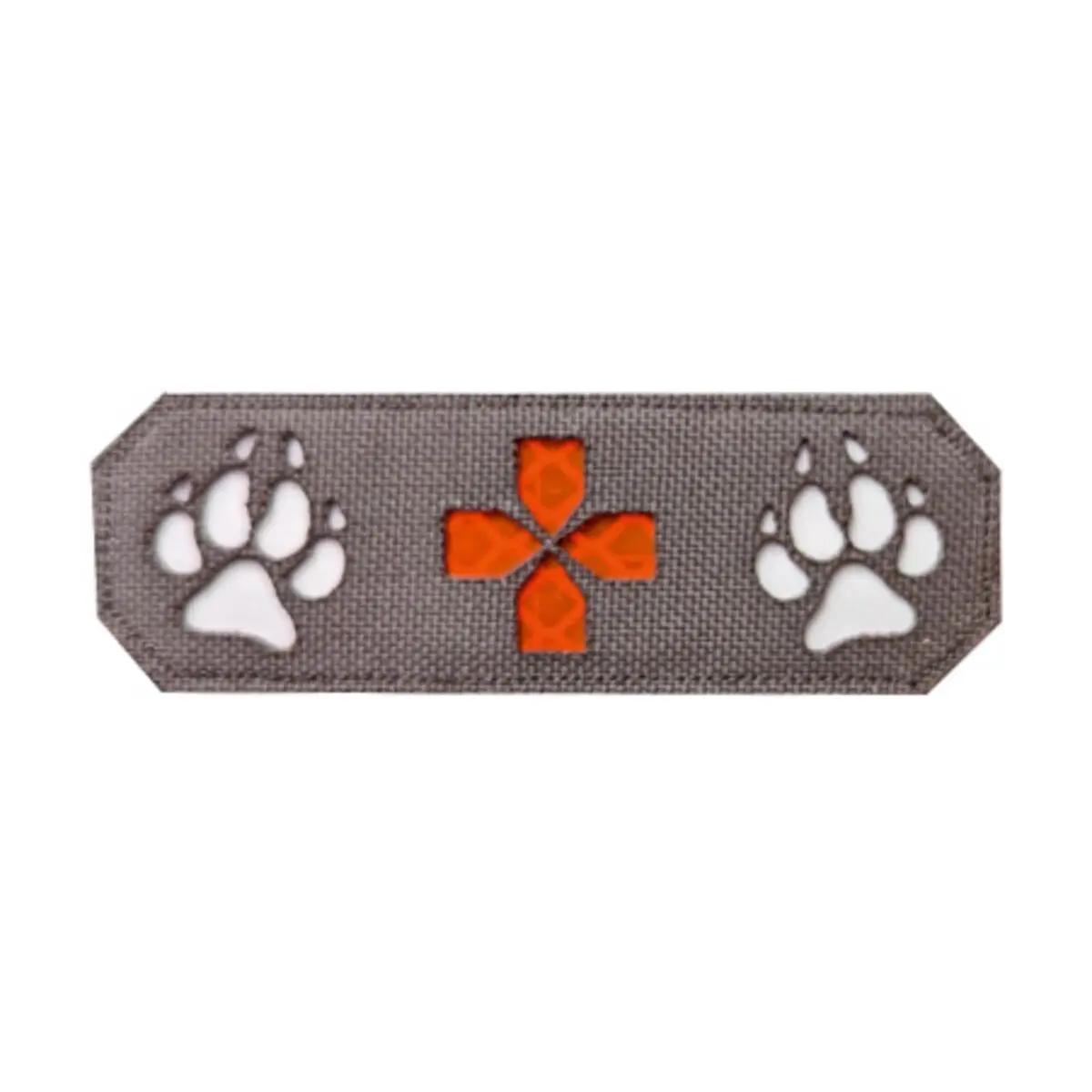 Rechteckiger Patch Lasercut K9 + rotes Kreuz - K9 aus grauem Stoff, mittig rotes Kreuz mit strukturierter Oberfläche und orangefarbene Pfotenabdrücke.