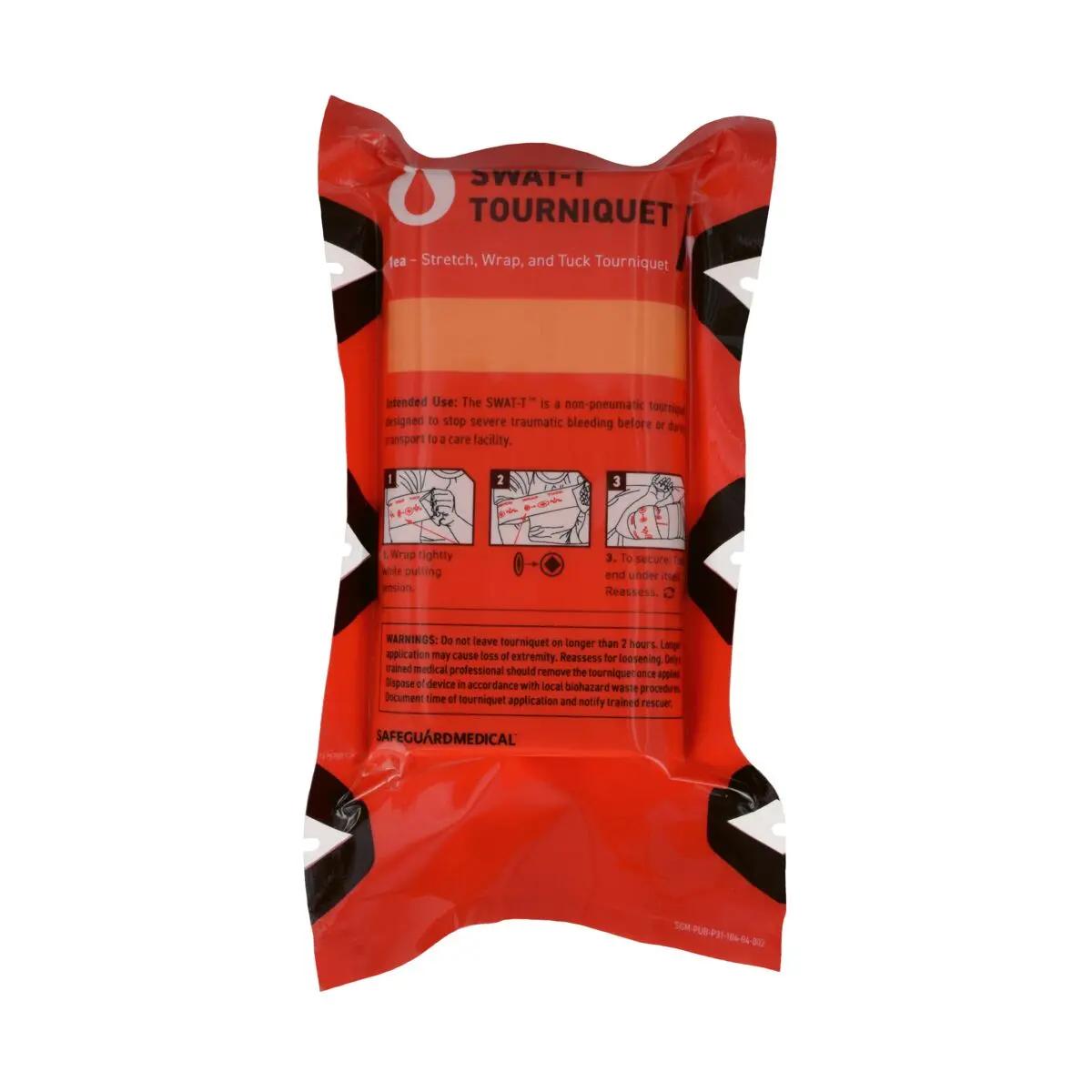 Die Verpackung des Tourniquet SWAT - T - Orange mit Schritt-für-Schritt-Anleitung und roter Kennzeichnung ist leicht nach rechts geneigt zu sehen.