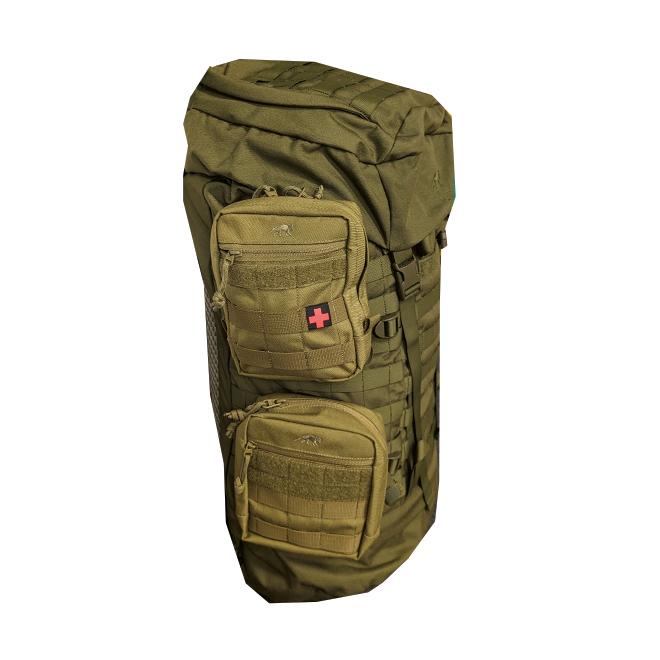 NightStripes - Rotes Kreuz Patch aus zertifiziertem Polyesterstoff mit rotem Kreuz und Druckknopfbefestigung an einer Seitentasche eines olivgrünen Rucksacks.