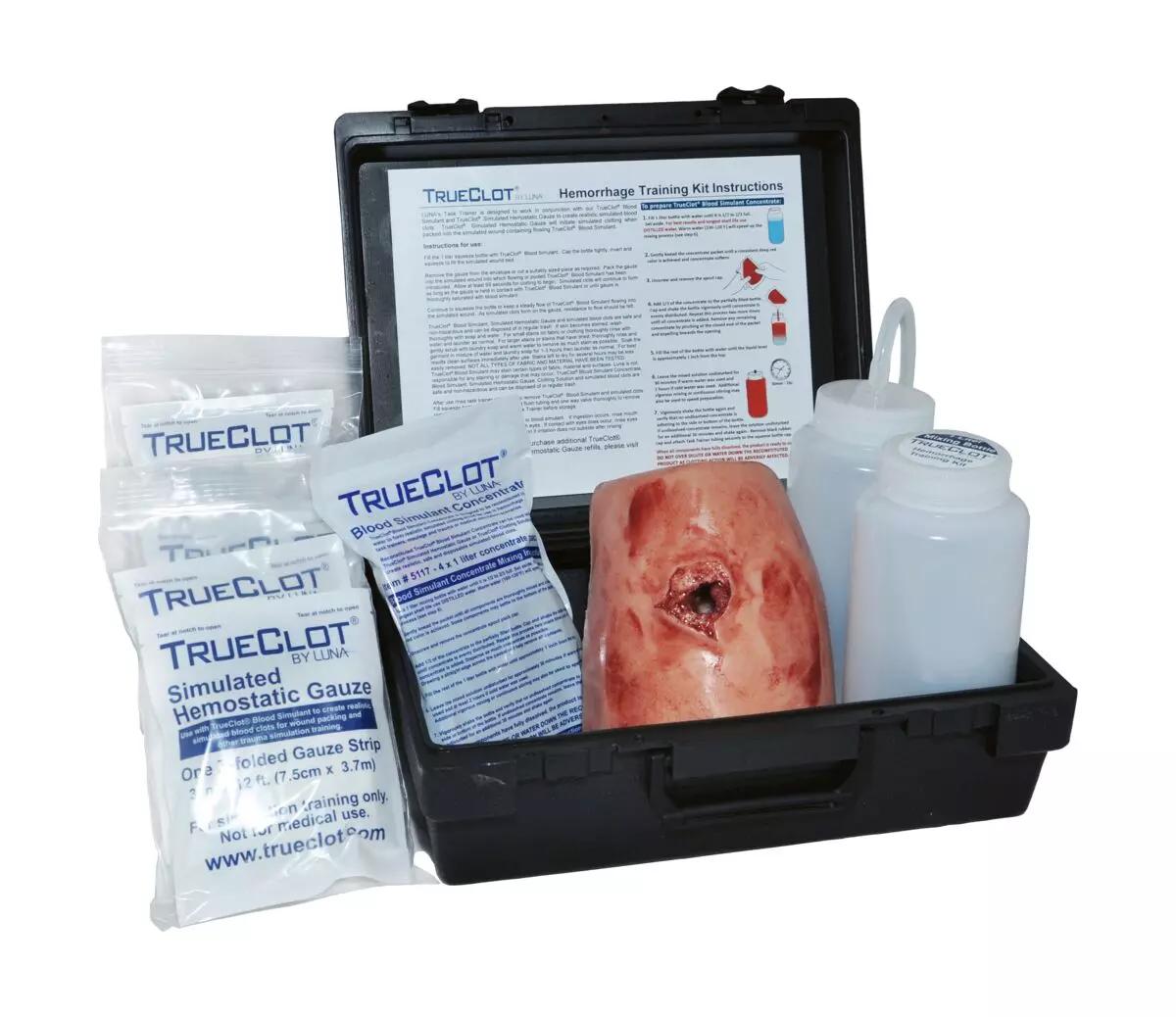 Das geöffnete TrueClot® Woundpacking Trainingssystem – Schusswunde enthält Kunstblut, einen Wundmodell-Tasktrainer sowie Anleitung und Zubehör für realistisches Blutstillungstraining.
