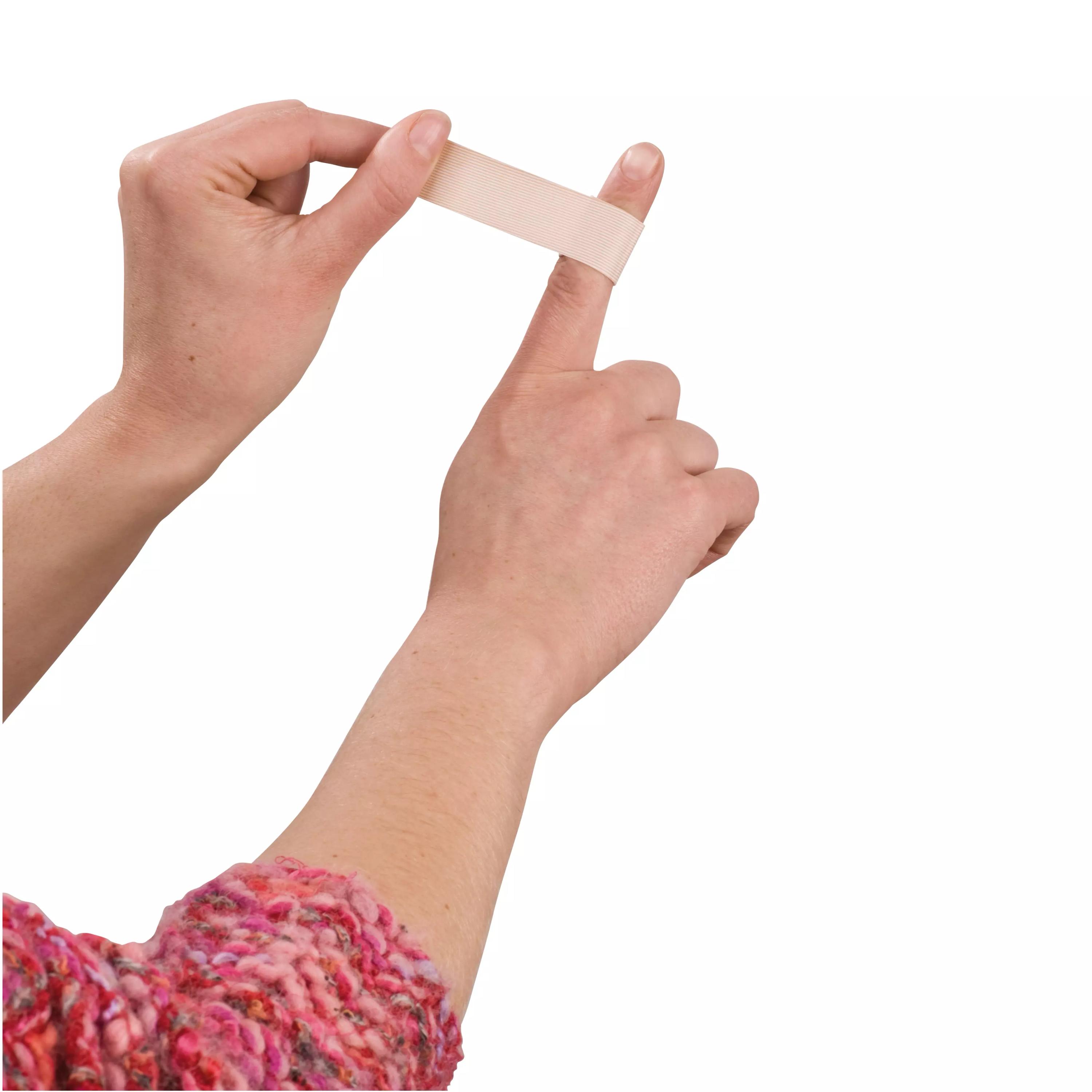 Eine Hand hält das Fingerpflaster Weroplast® AquaFlex - 2 cm, 12 cm, das wasserdicht, superelastisch und flexibel über einem Finger gespannt wird.