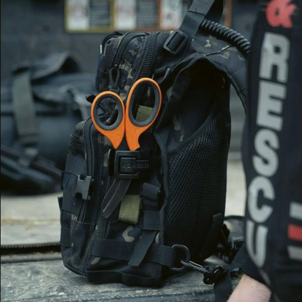 XSHEAR® Micro Holster/Halter in schwarz-grauem Camouflage-Design mit orangefarbener Schere am Tragegriff, ultraleicht und anpassungsfähig.