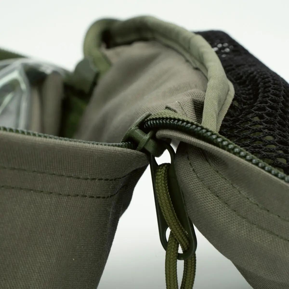 Der PARAMEDYK® Notfallrucksack - Oliv zeigt einen teils geöffneten YKK-Reißverschluss am robusten CORDURA 1100dtex Material mit sichtbarem Meshfach.