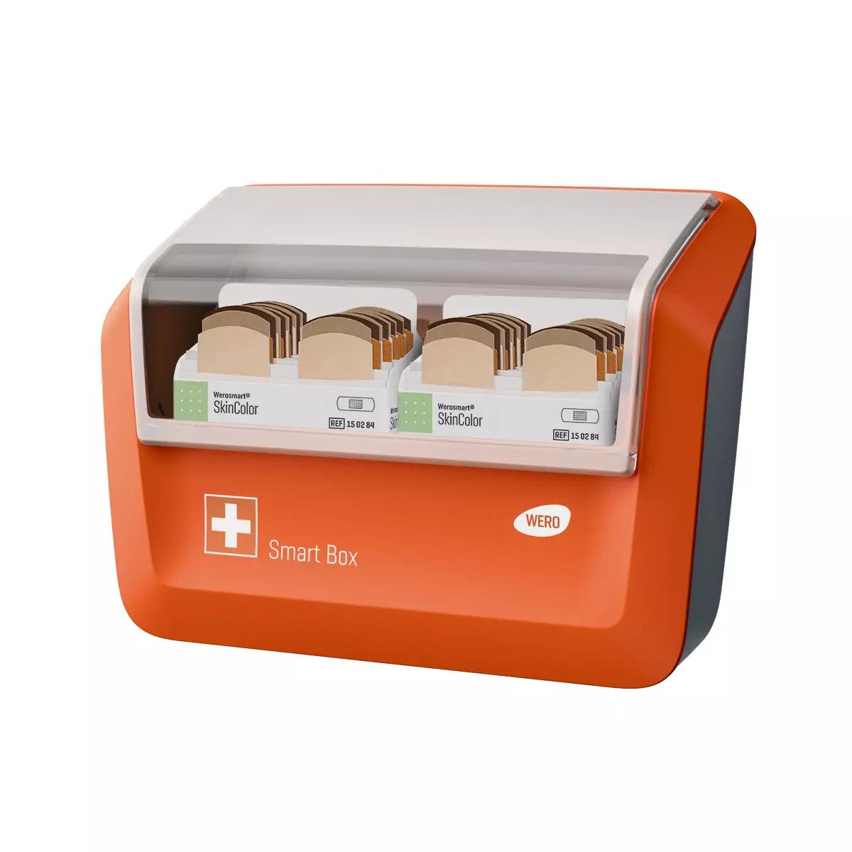 WERO Smart Box® Pflasterspender mit transparentem Frontdeckel, gefüllt mit SkinColor Pflasterstrips in mehreren einzeln beschrifteten Fächern.