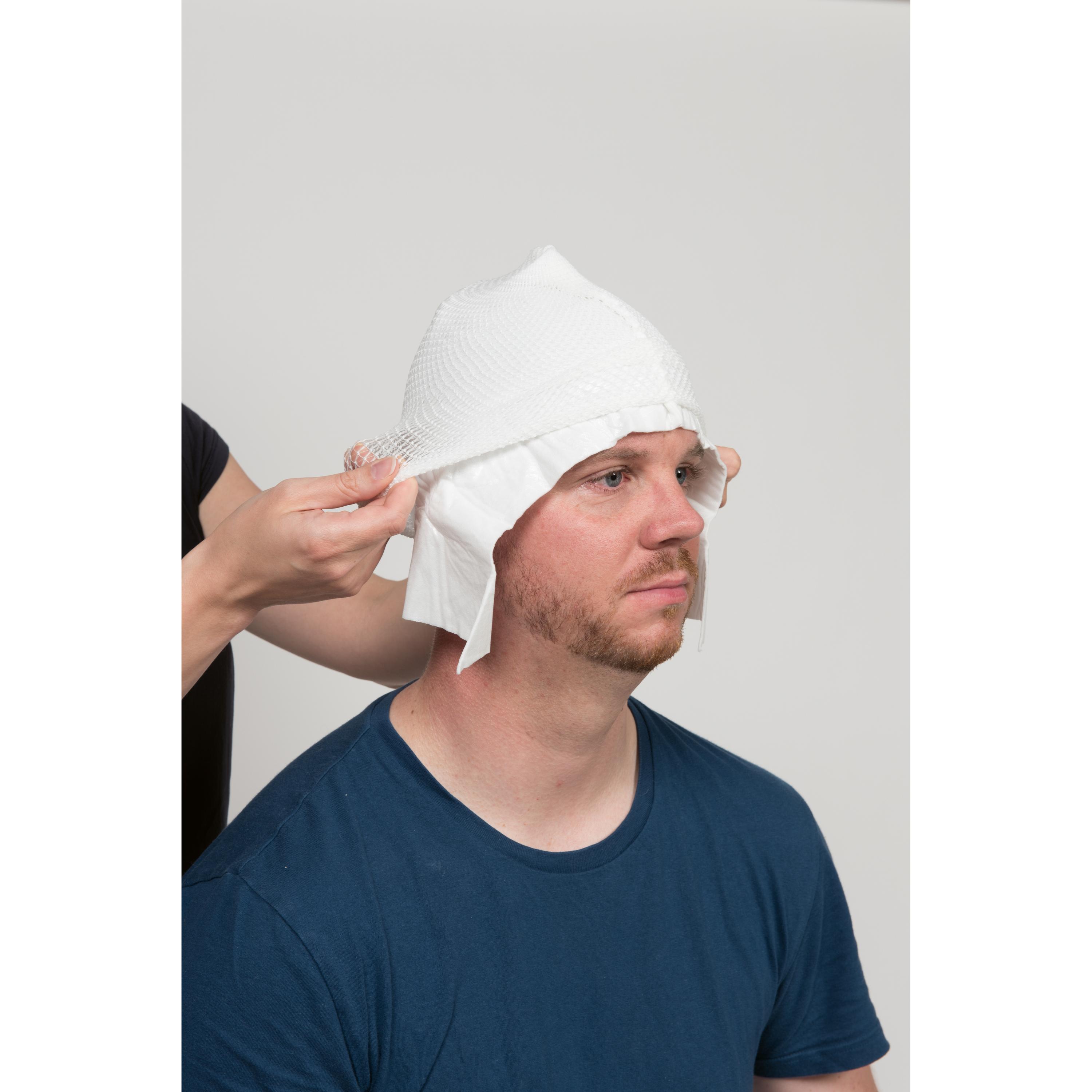 Ein Mann trägt einen WERO MediCap Kopfschnellverband, steril, als weiße, texturierte Wundauflagen-Haube mit integriertem Netzverband, die am Kopf angepasst wird.
