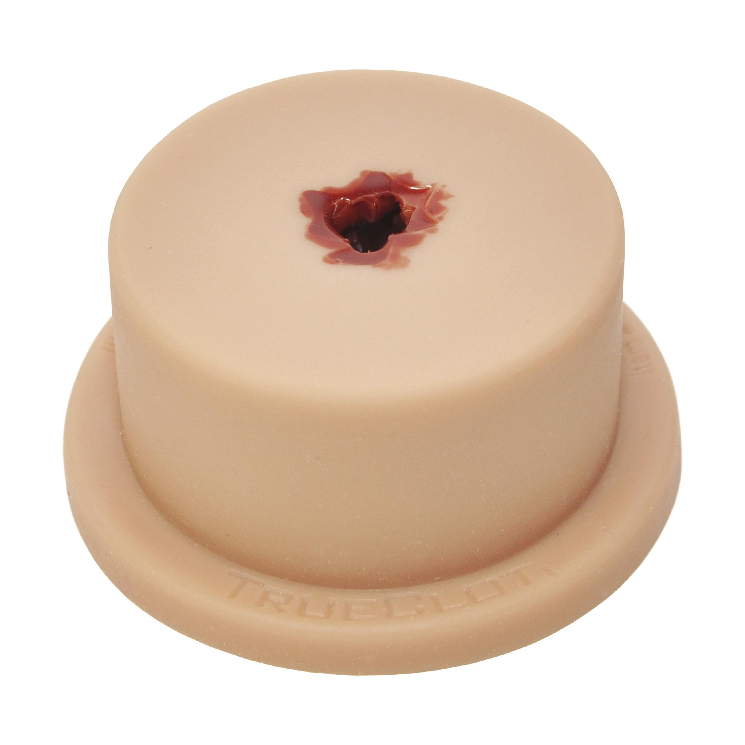 Runder TrueClot® Basic Packing Trainer mit beiger Oberfläche, zentralem Loch mit dunkelroter Flüssigkeit und flacher Standbasis mit TRUEGLOT-Prägung.