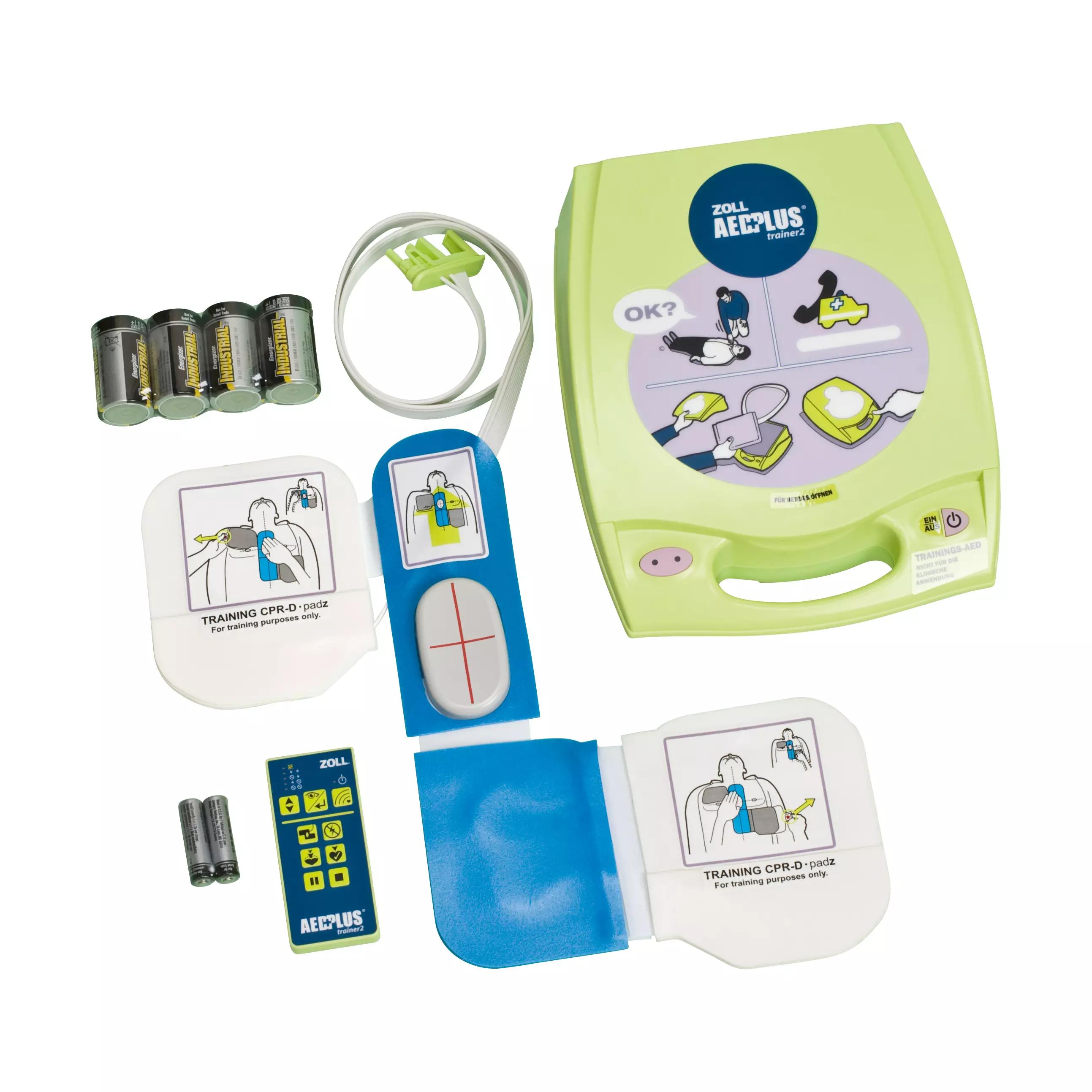 Übungsdefibrillator ZOLL® AED Plus Trainer2 mit grüner Hülle, Display, Fernbedienung, Anleitung und vier Batterien als Trainingsset gezeigt.