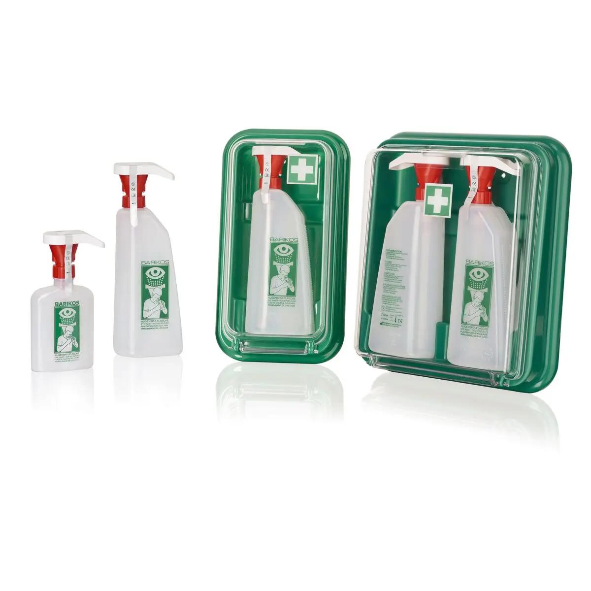 Vier Augenspülflaschen Barikos KS, 620 ml, mit roten Sprühköpfen und grünen Etiketten, teils in grünen Erste-Hilfe-Boxen mit Sichtfenster und Kreuz-Symbol.